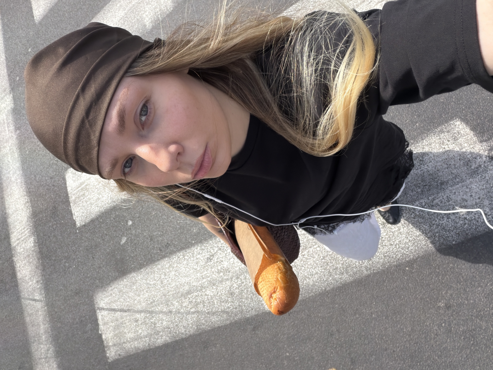 Woman with baguette crosses Tel Aviv street Monday morning