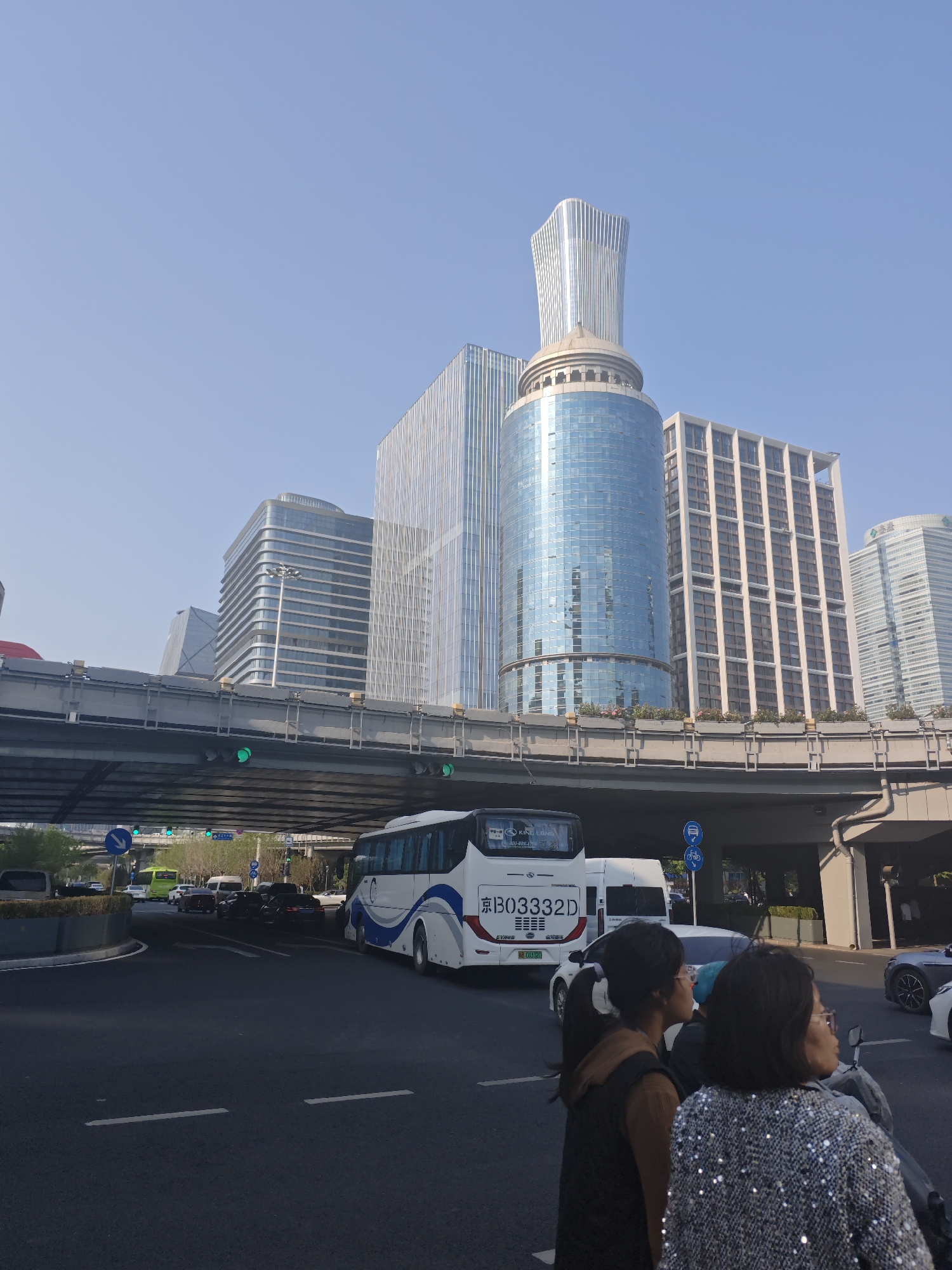 Pedestrians cross busy Chaoyang District intersection on clear Beijing day