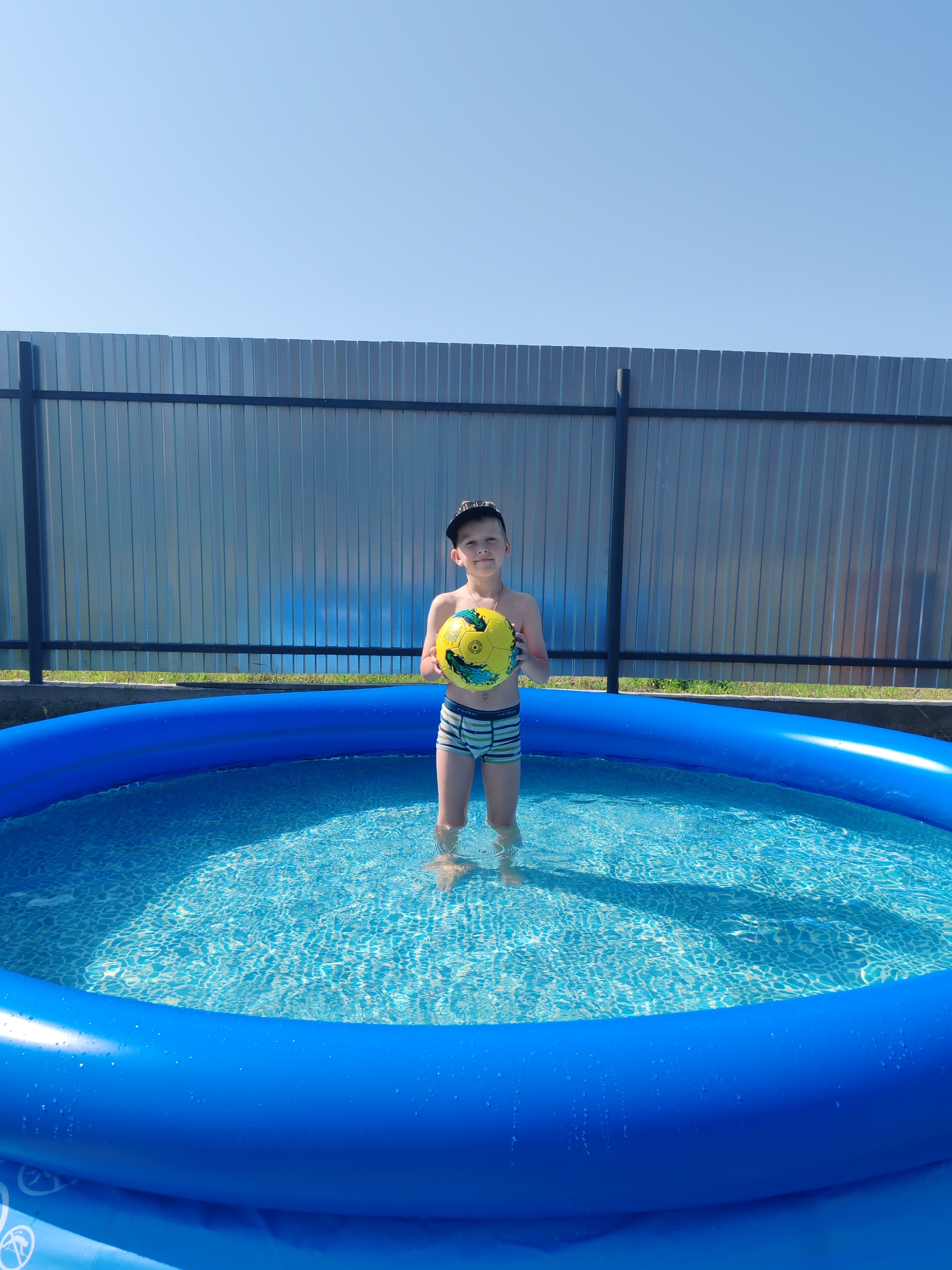 Backyard inflatable pool fun on a summer morning in Chaikovsky