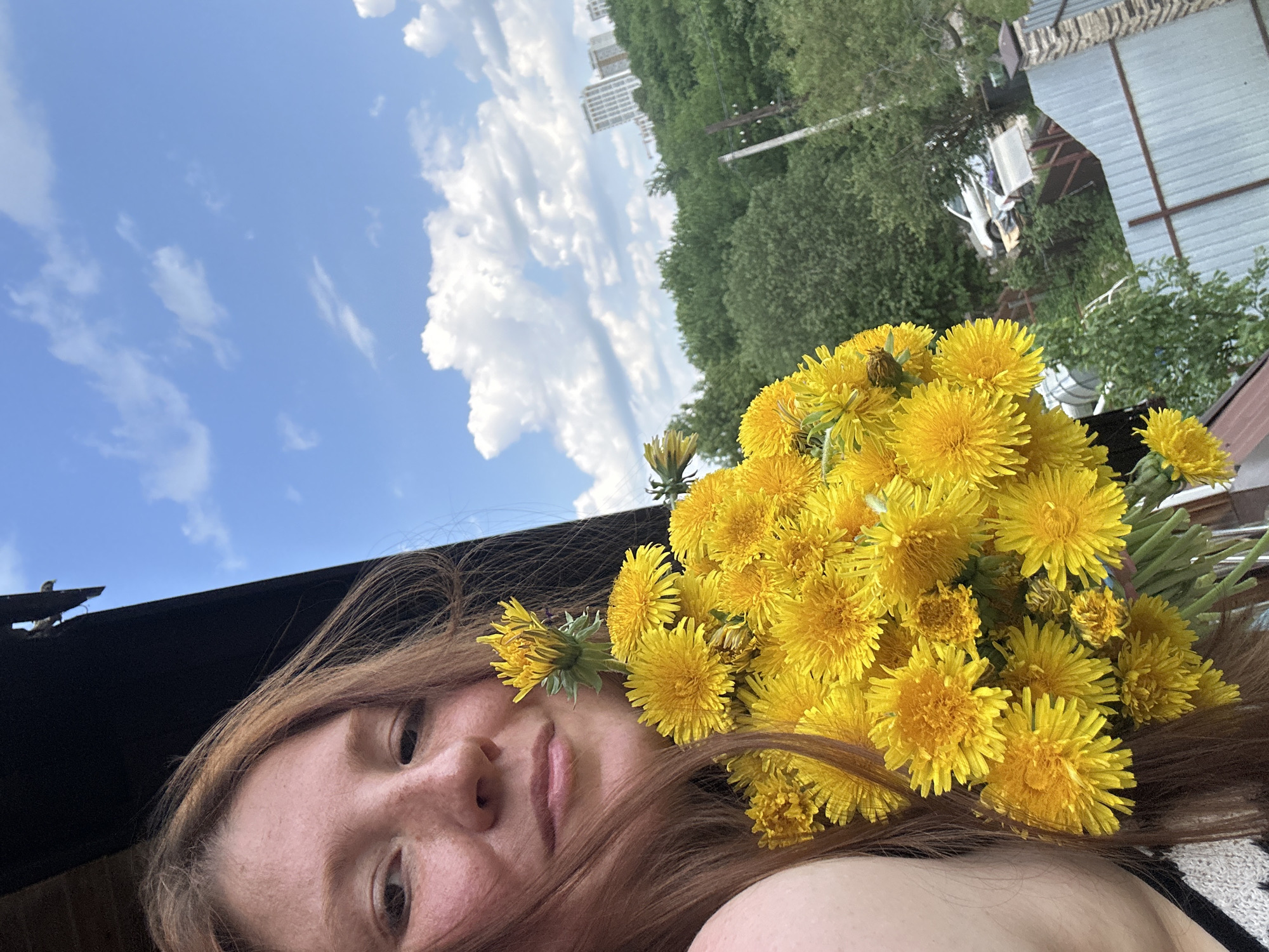 Woman poses with dandelion bouquet on Nizhny Novgorod balcony