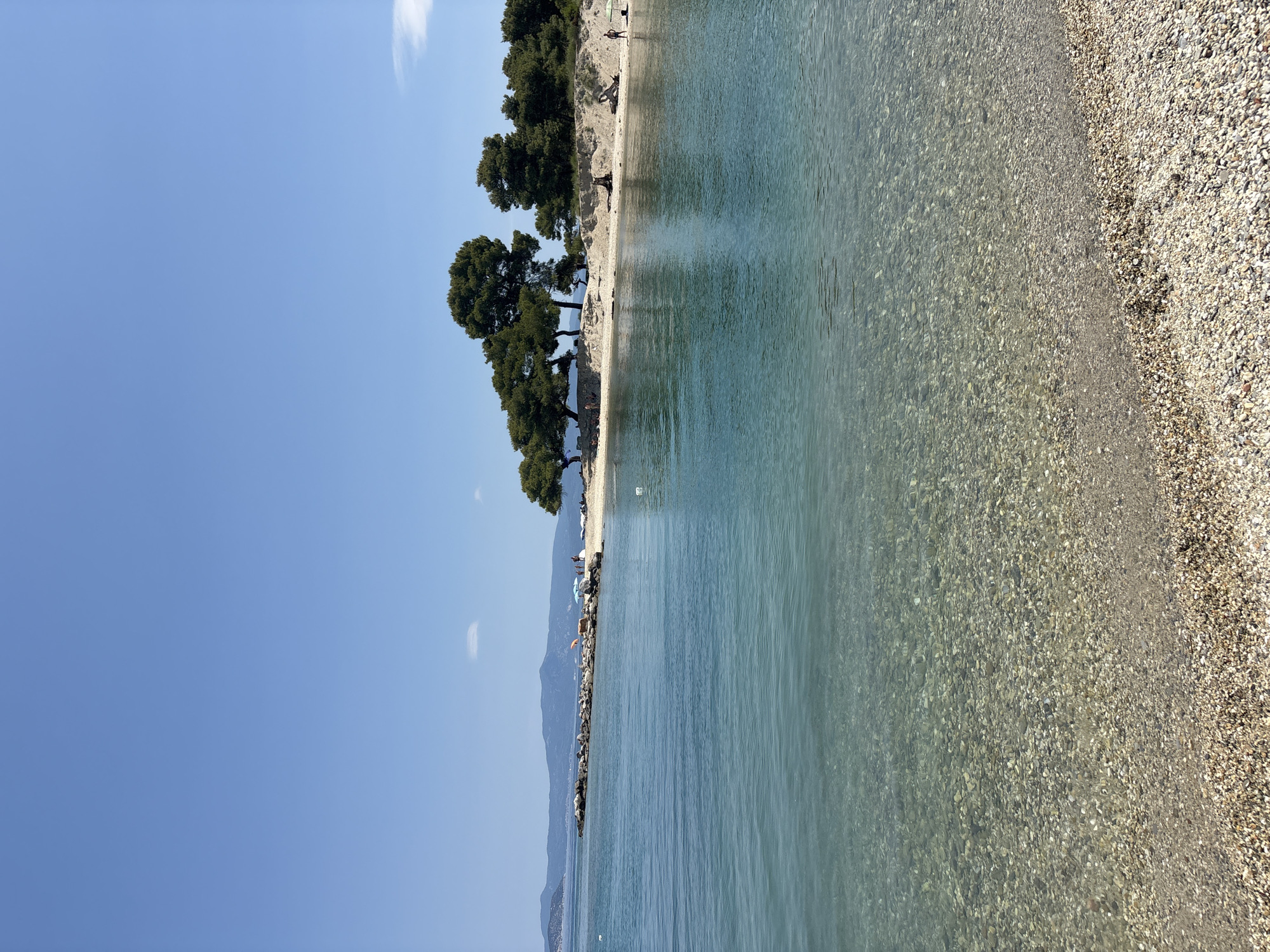 Crystal-clear turquoise water at a Greek pebble beach