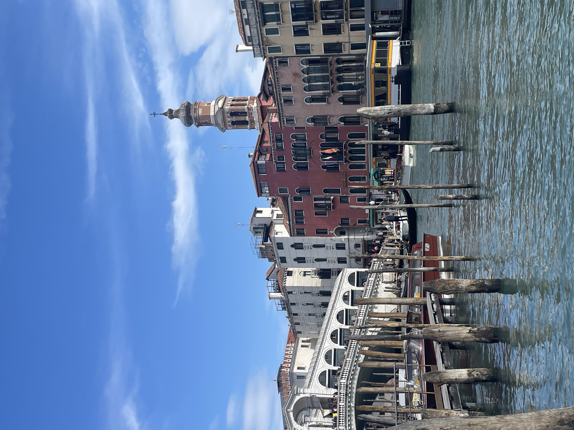 Tourist takes selfies at Venice's Rialto Bridge on sunny day