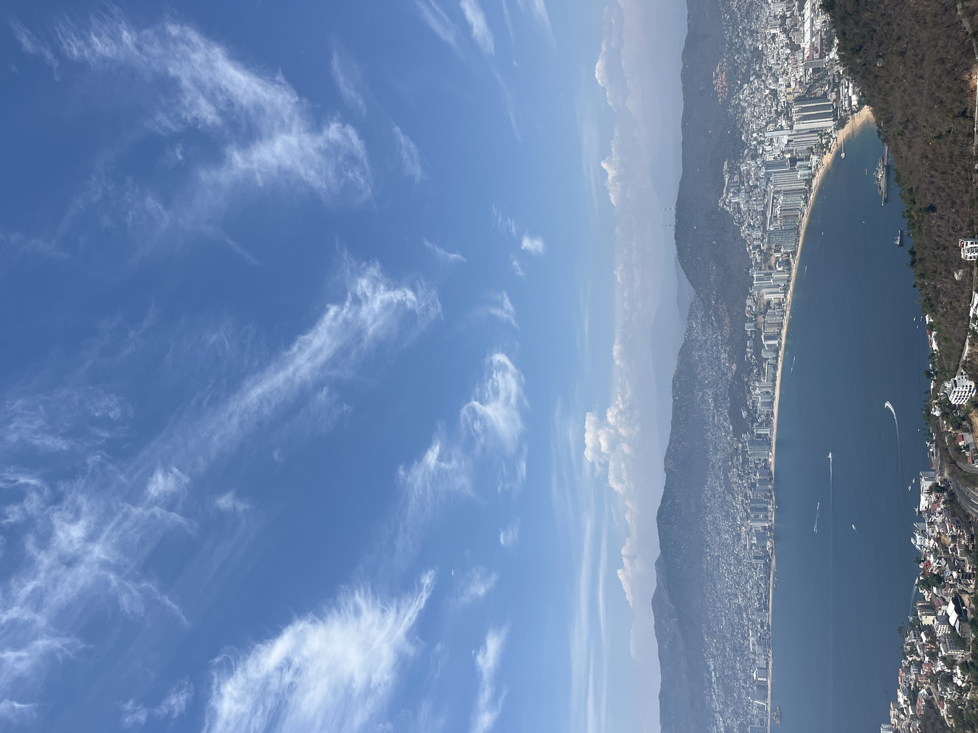 Aerial view captures Acapulco's coastal skyline under clear skies