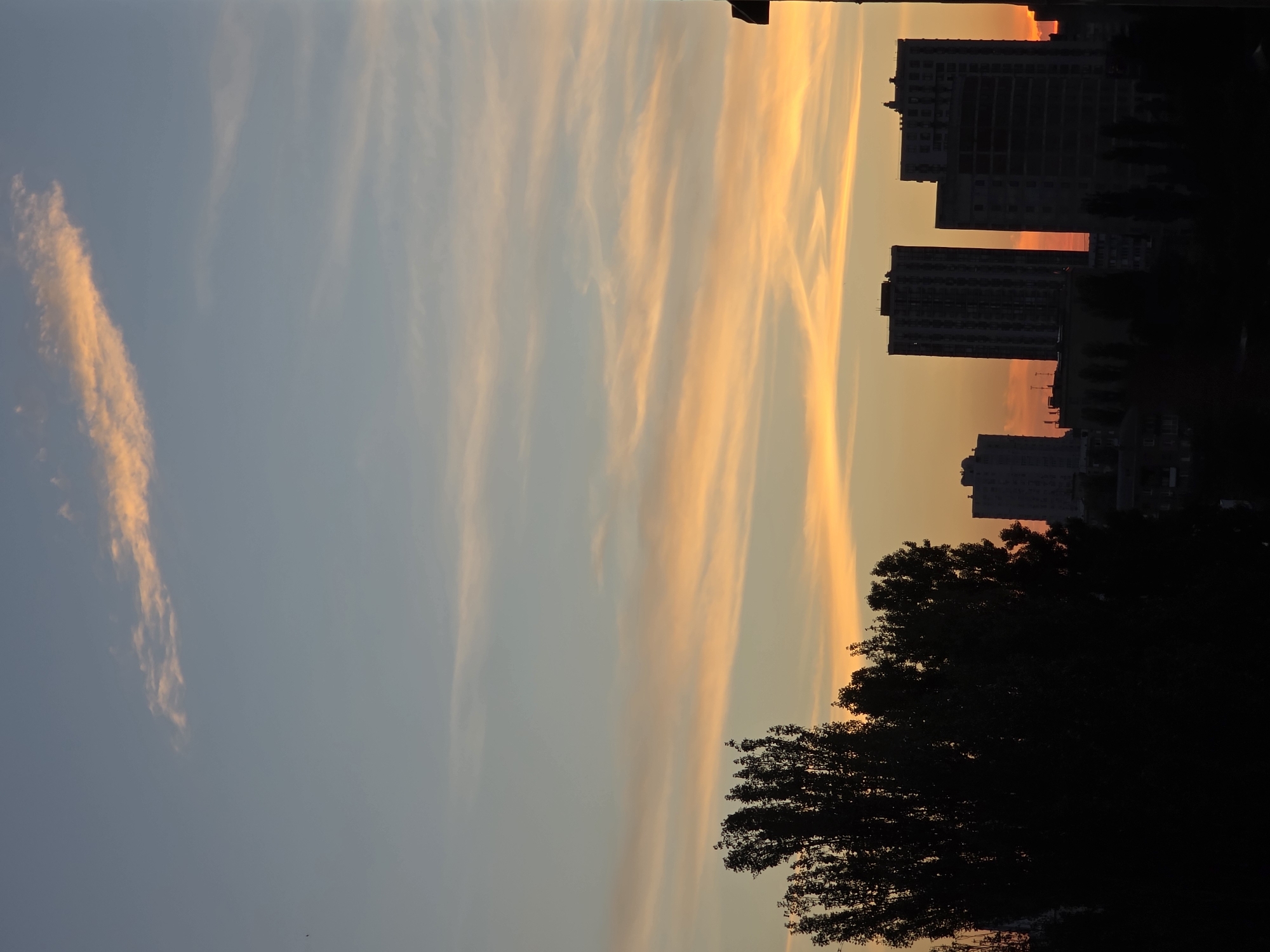 Kyiv at dusk: neighborhood rooftops, rising moon, fading sky