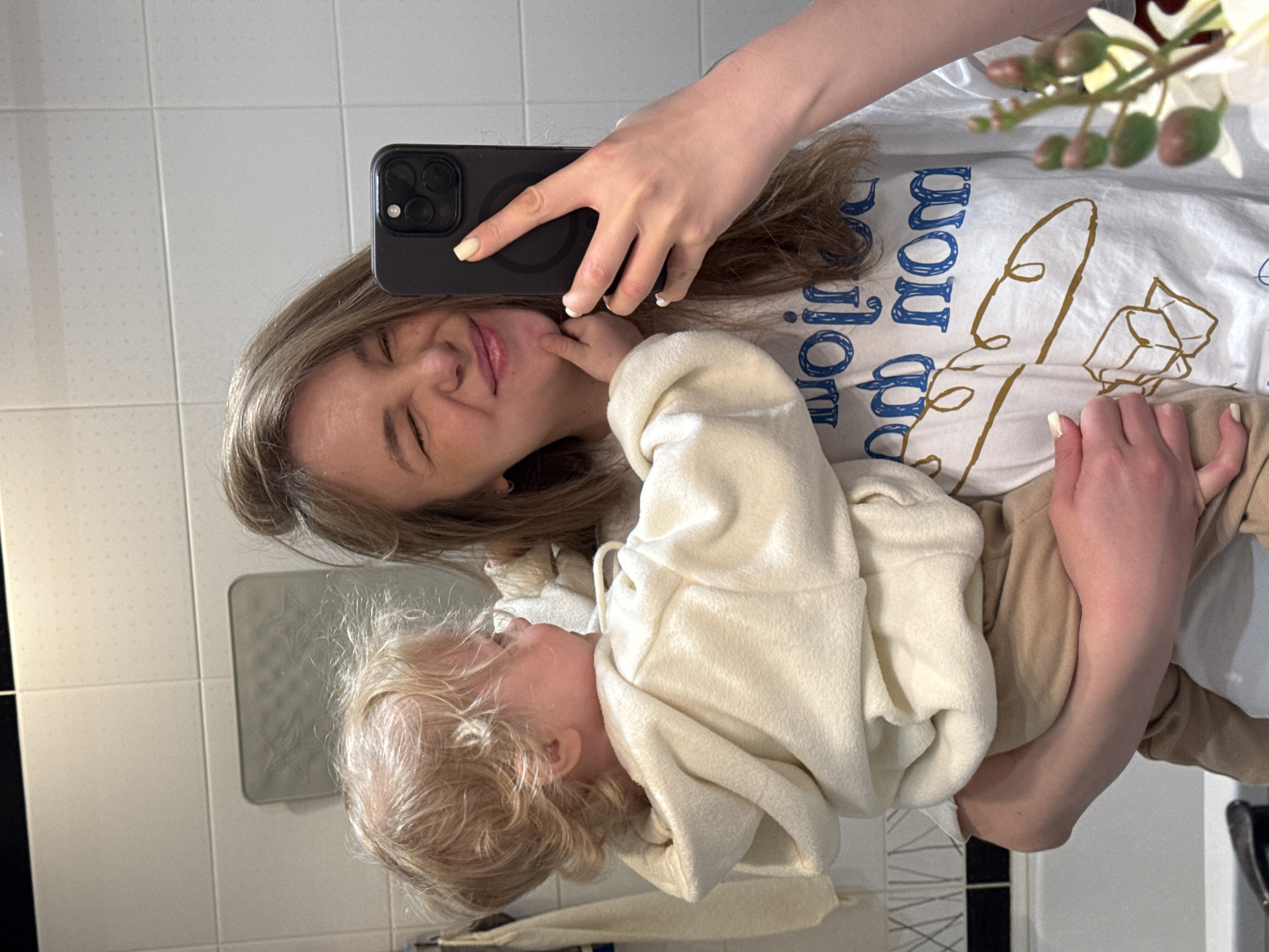 Mother takes bathroom selfie while holding baby in Vladimir