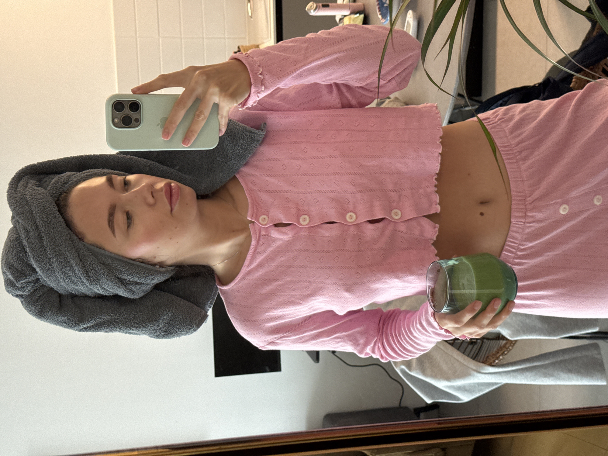 Woman takes mirror selfie with towel, pink outfit in Jordan