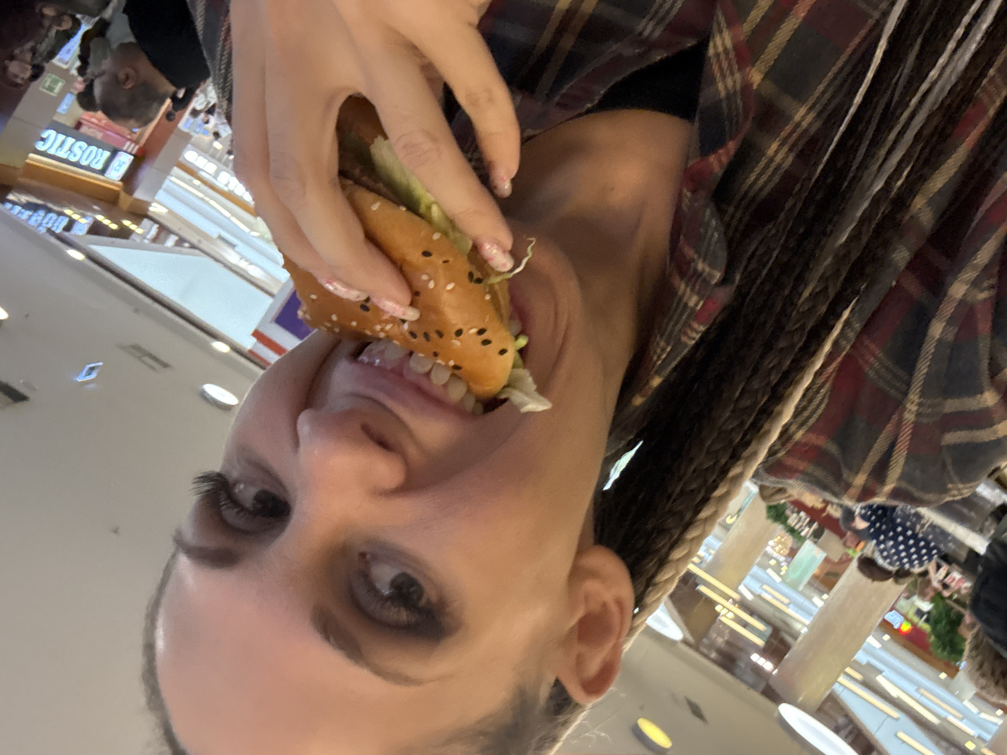 Person eats hamburger at Rusanovo shopping mall