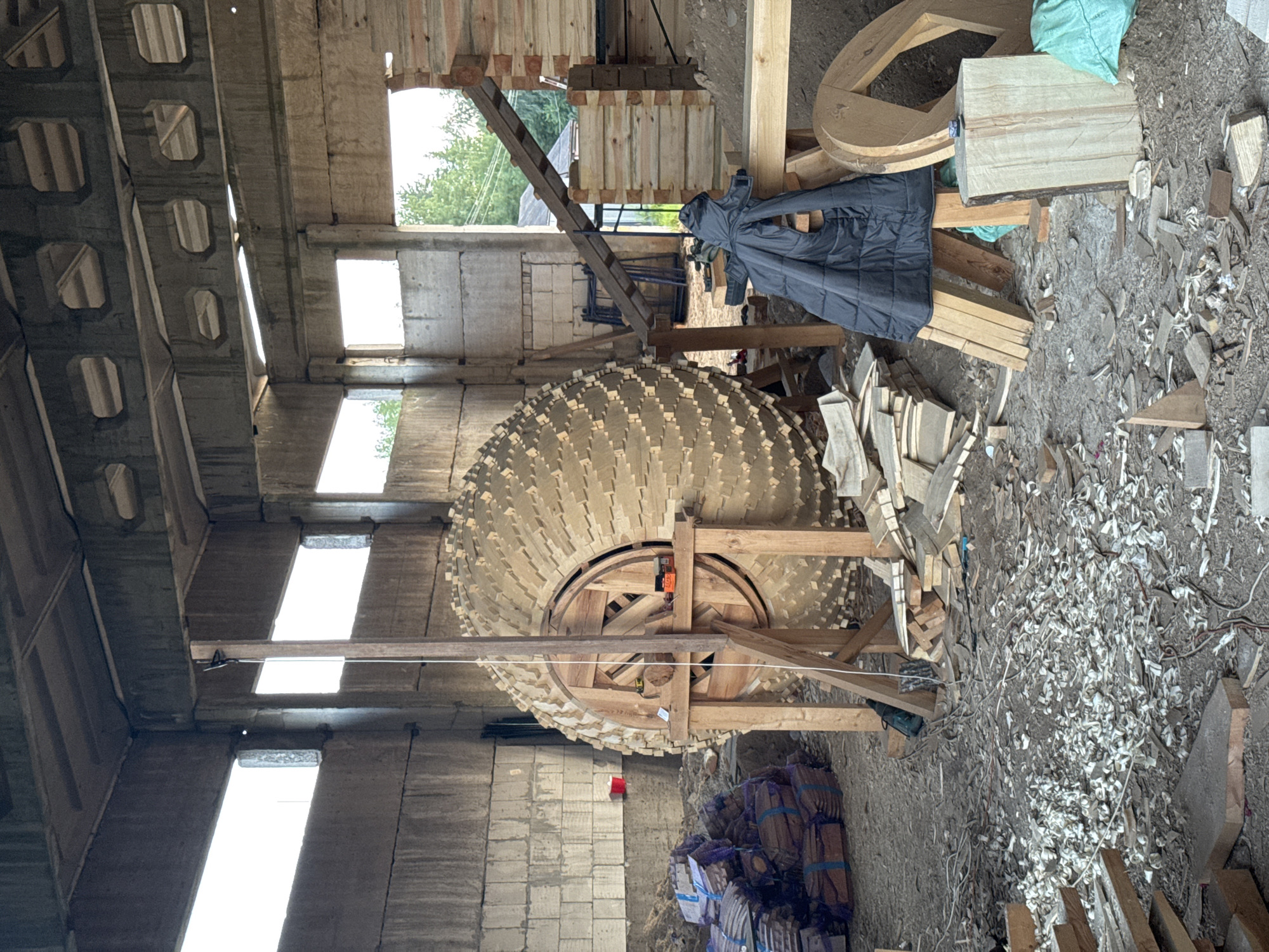 Large wooden sculpture taking shape at a rural Belarusian construction site
