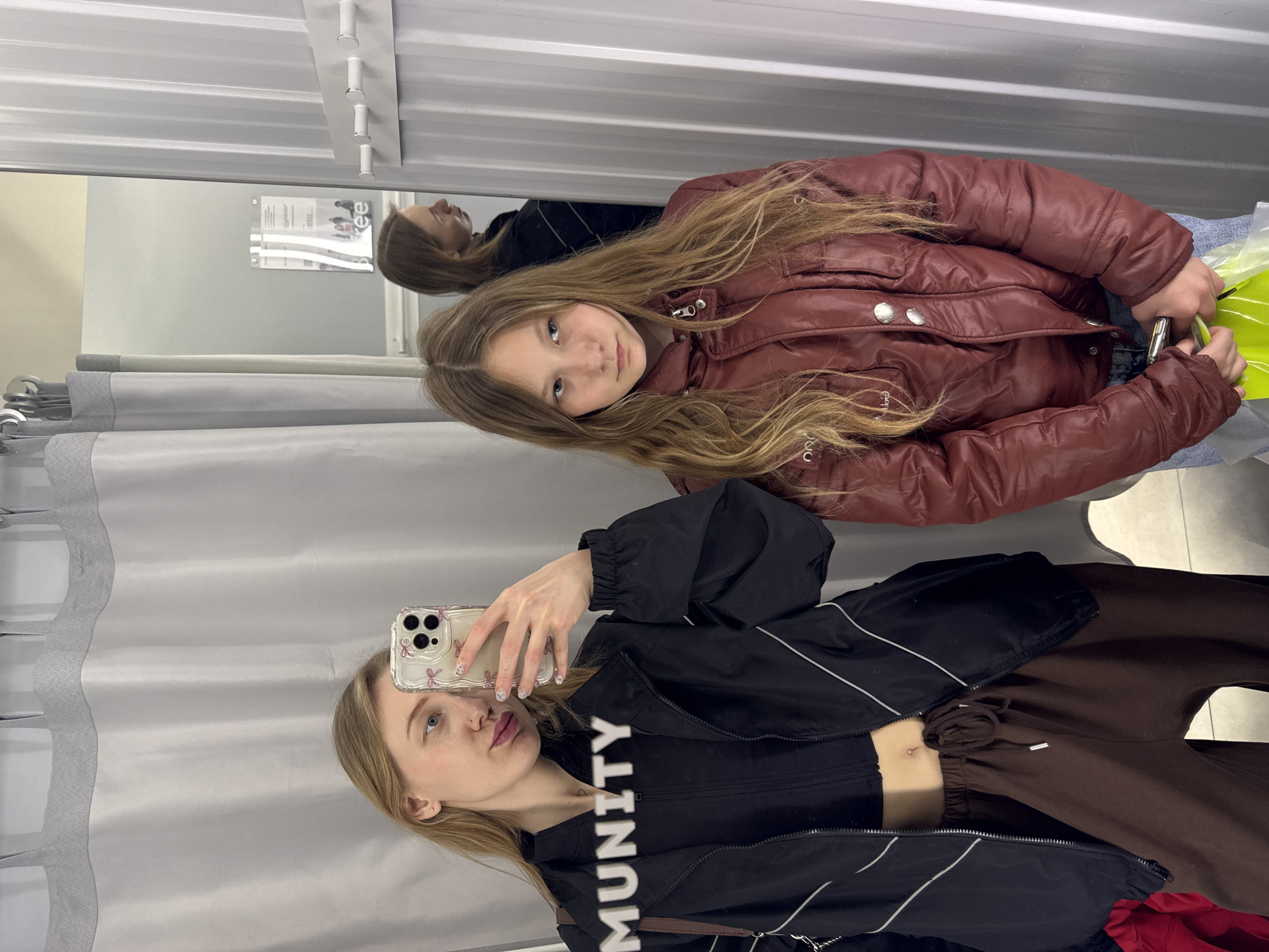 Friends take selfies in Russian clothing store fitting room