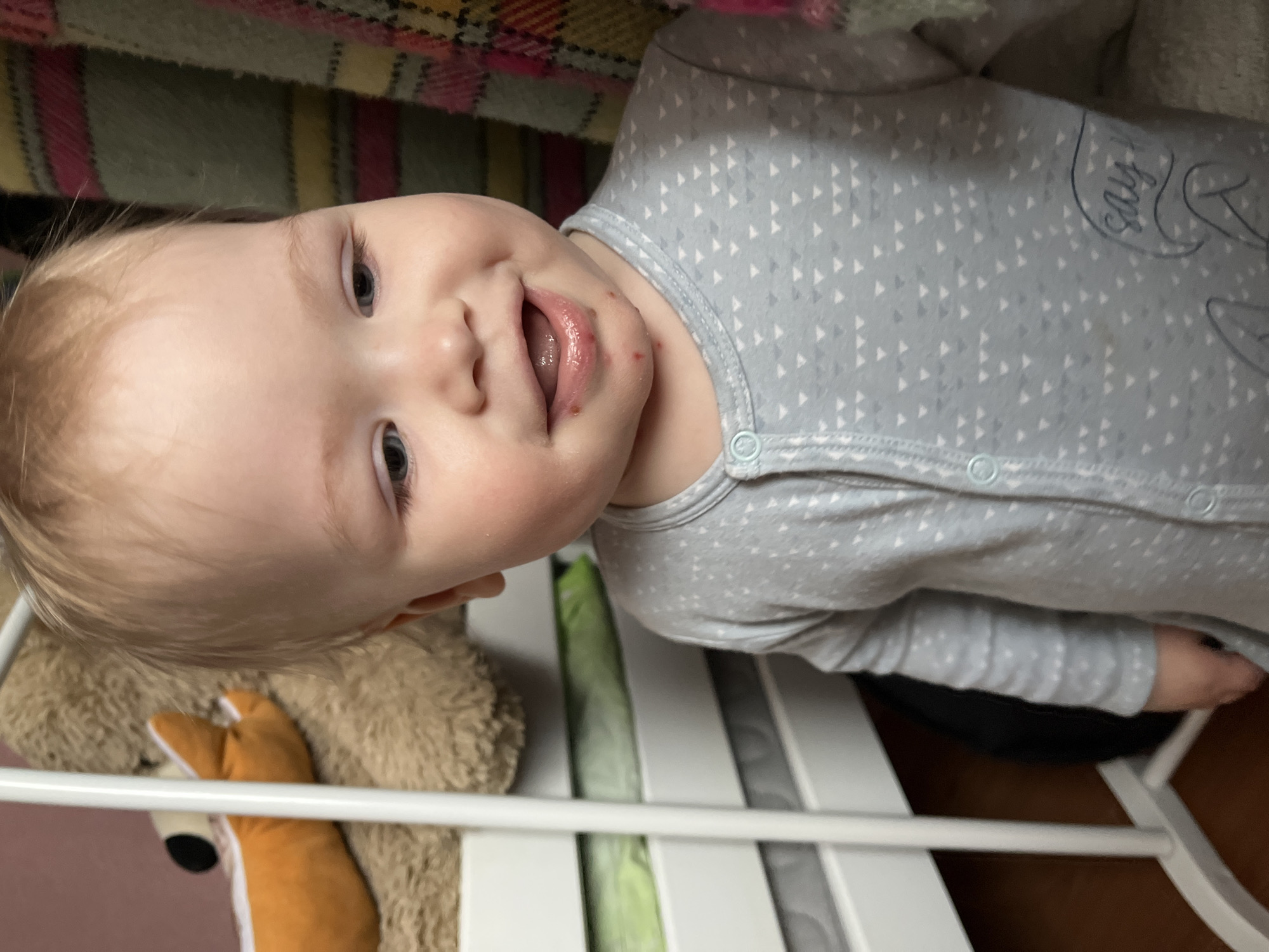 Baby plays with doll while cat poses near window