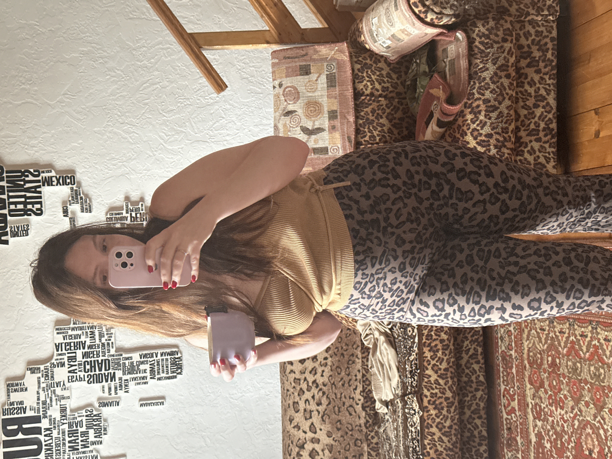 Woman takes mirror selfie with phone and cup in Belarus