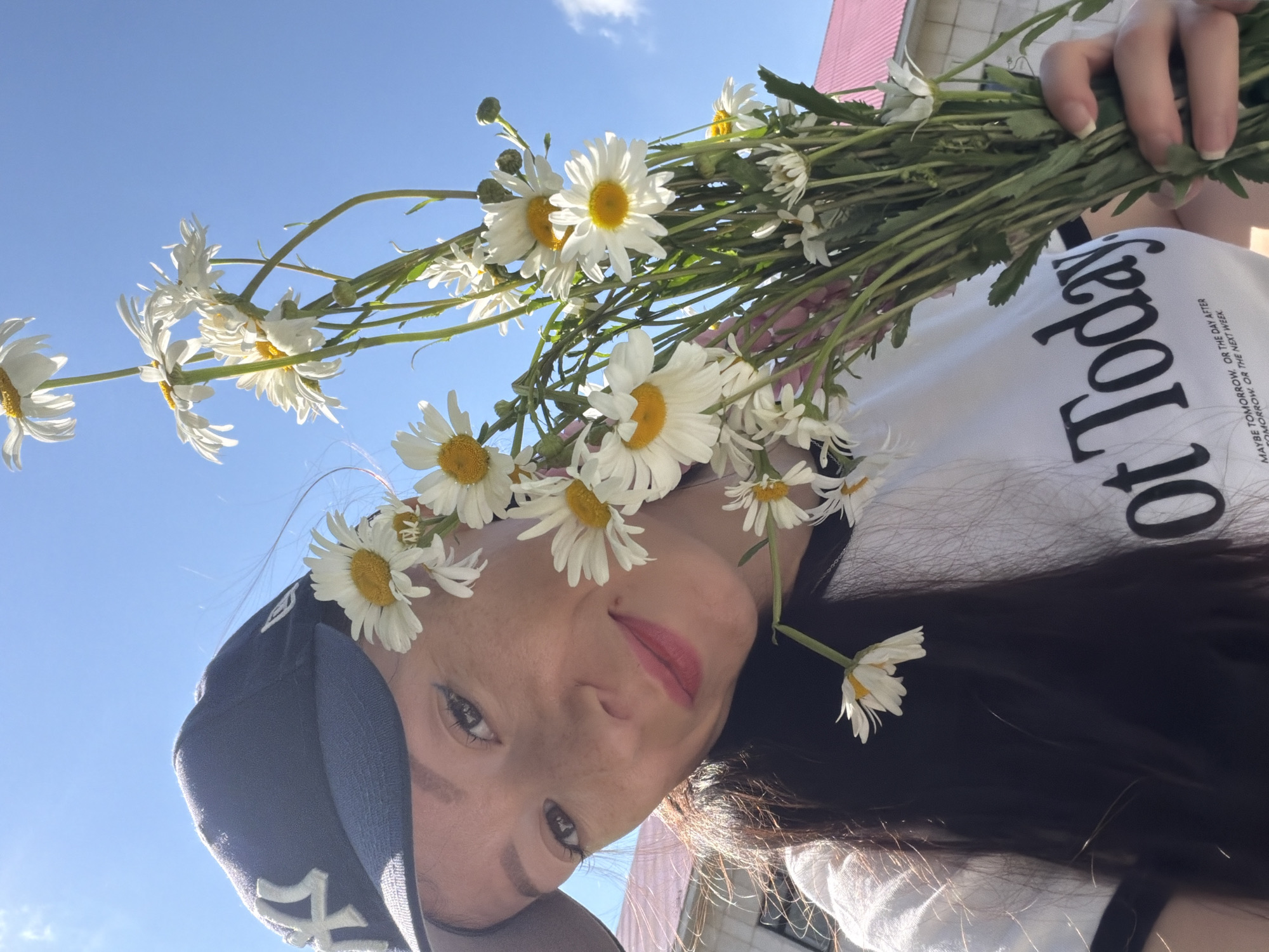 Woman poses with daisy bouquets during outdoor gathering in Tujmazy