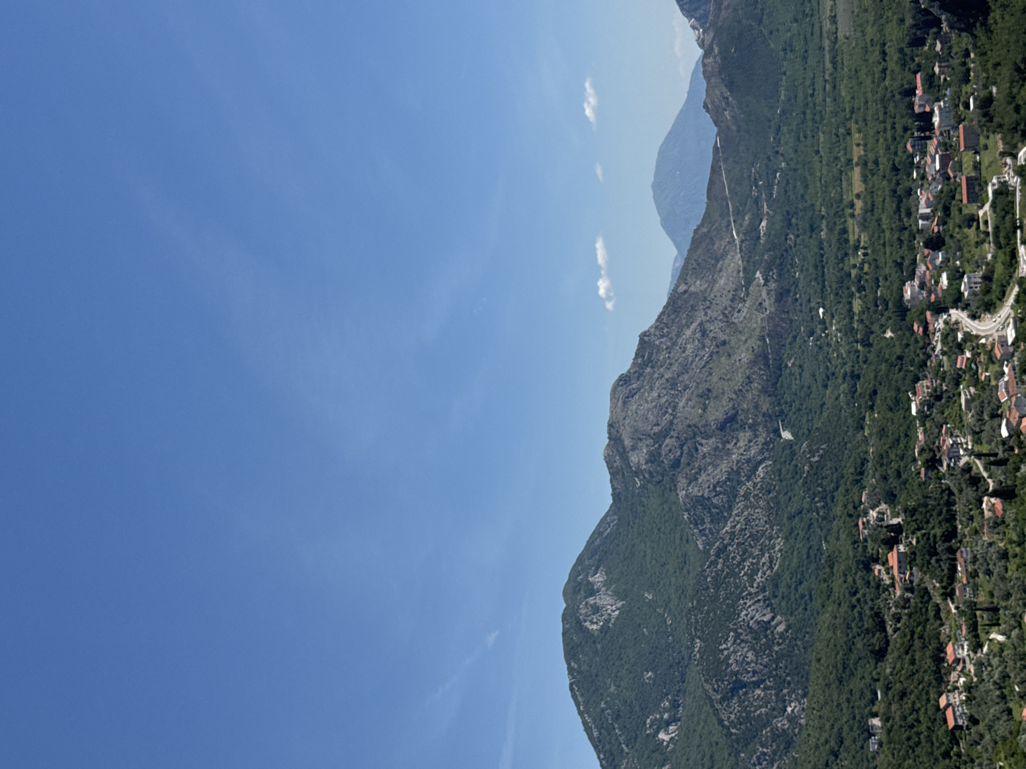 Tourist documents scenic coastal views in Montenegro resort town