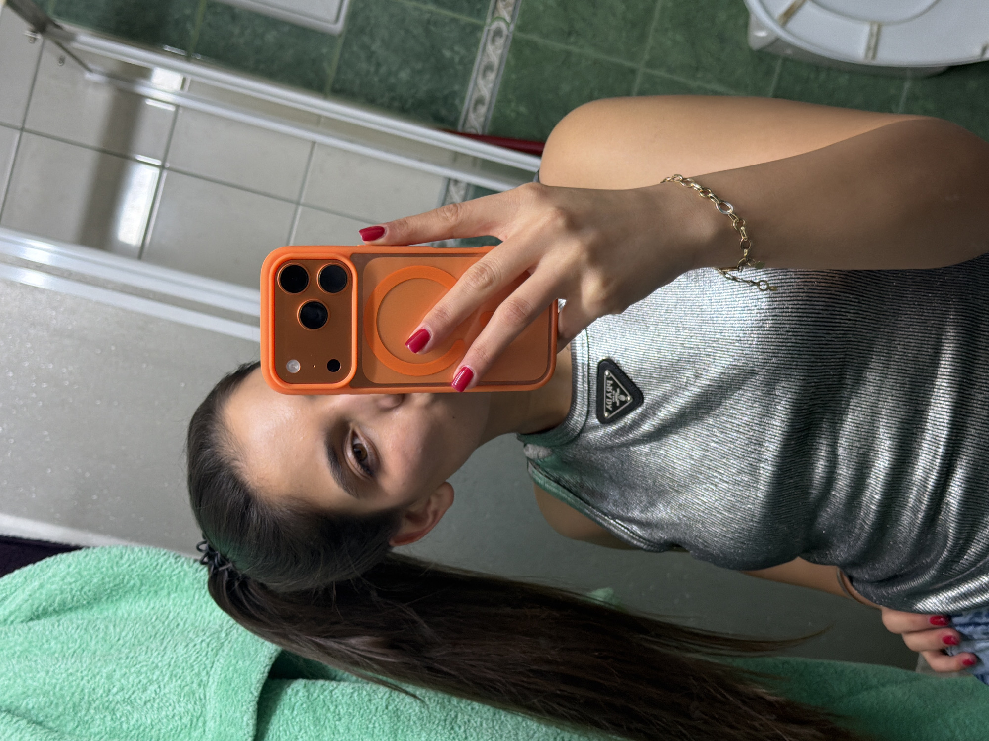 Woman takes bathroom selfie with orange iPhone in Bulgaria