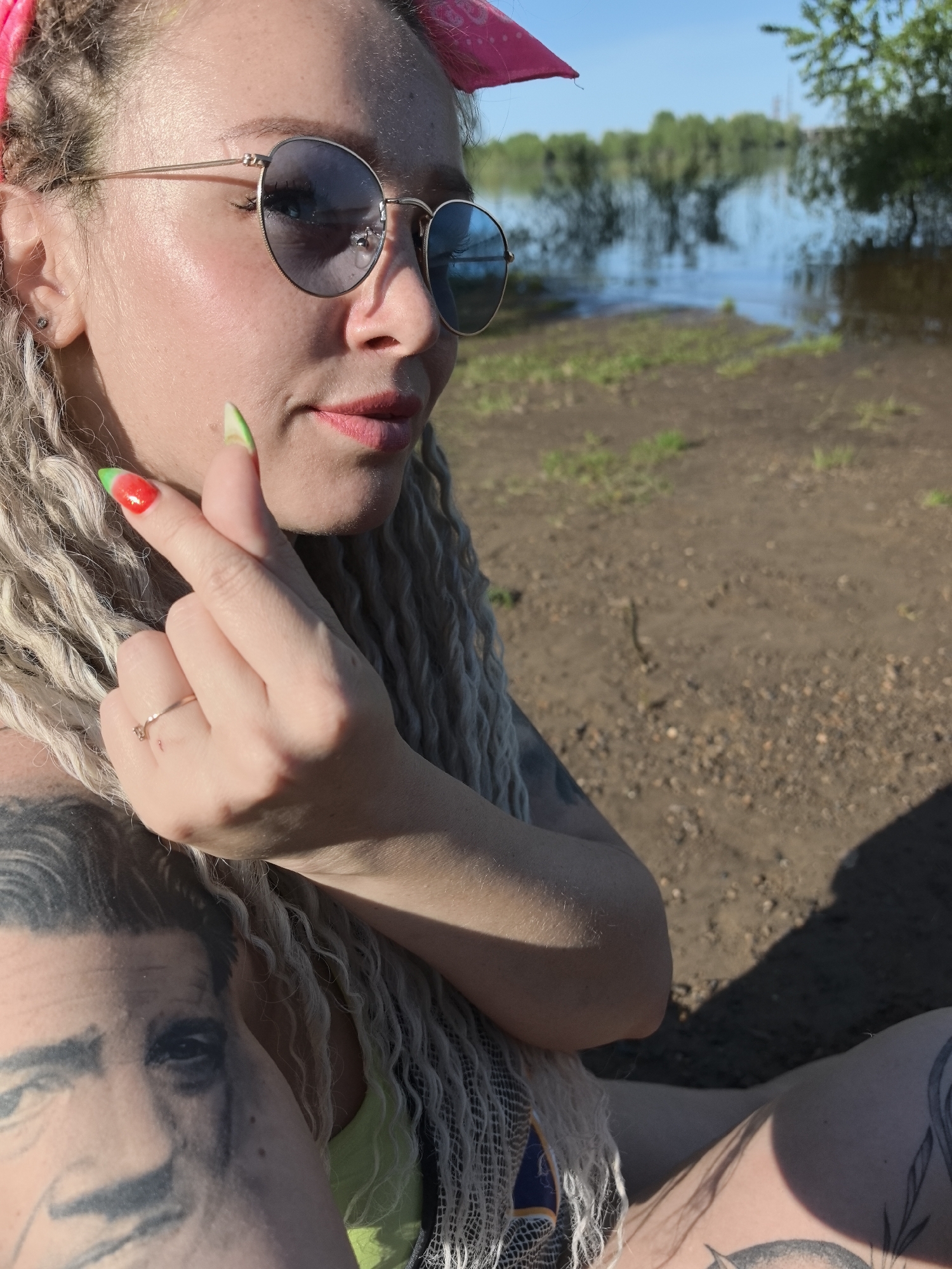 Tattooed woman with blonde dreadlocks spotted by water in Russia