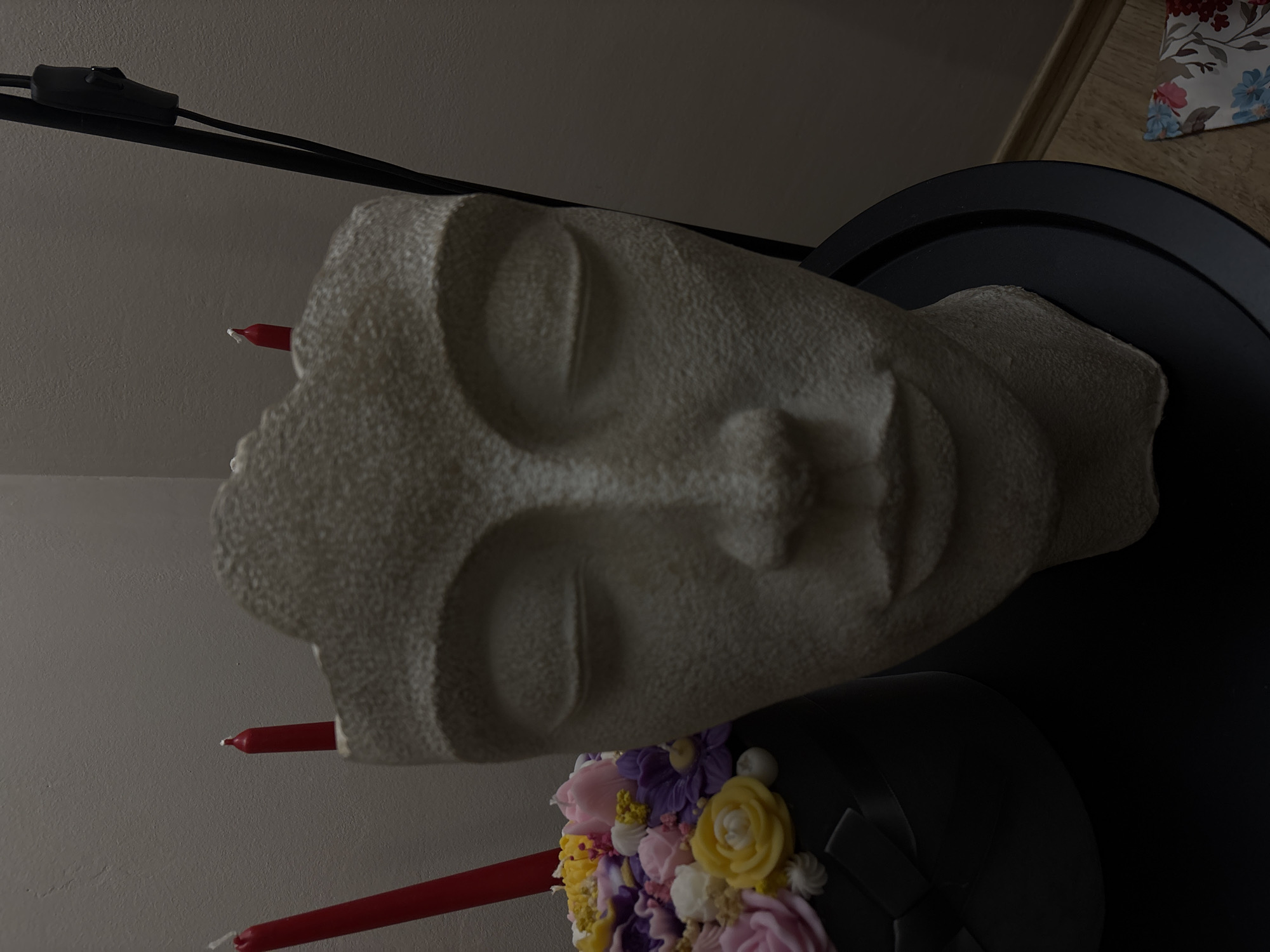 White sculptural face displayed with flowers in Veliko Tarnovo