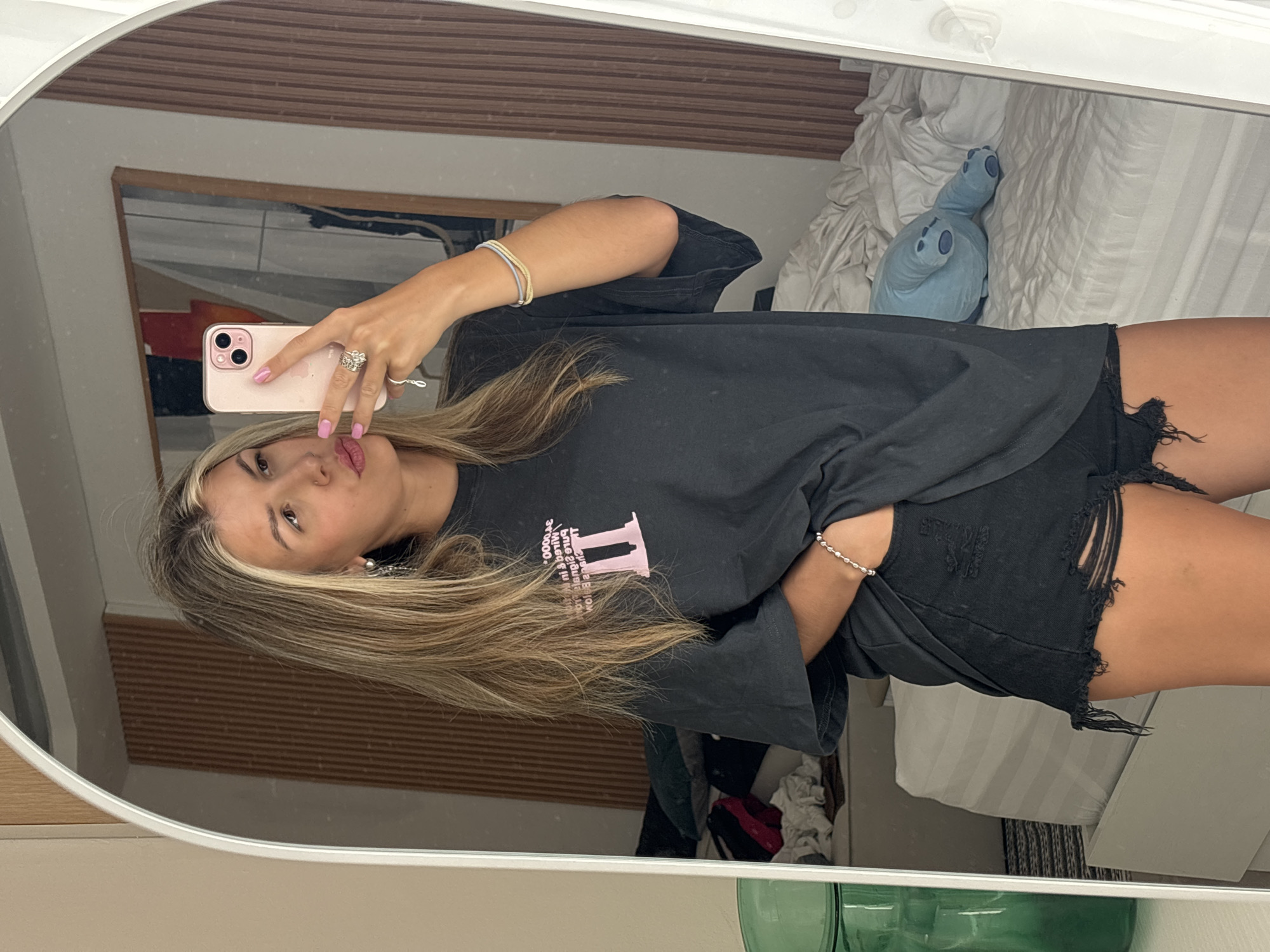 Mirror selfie session in a hotel room, outfit and phone in hand