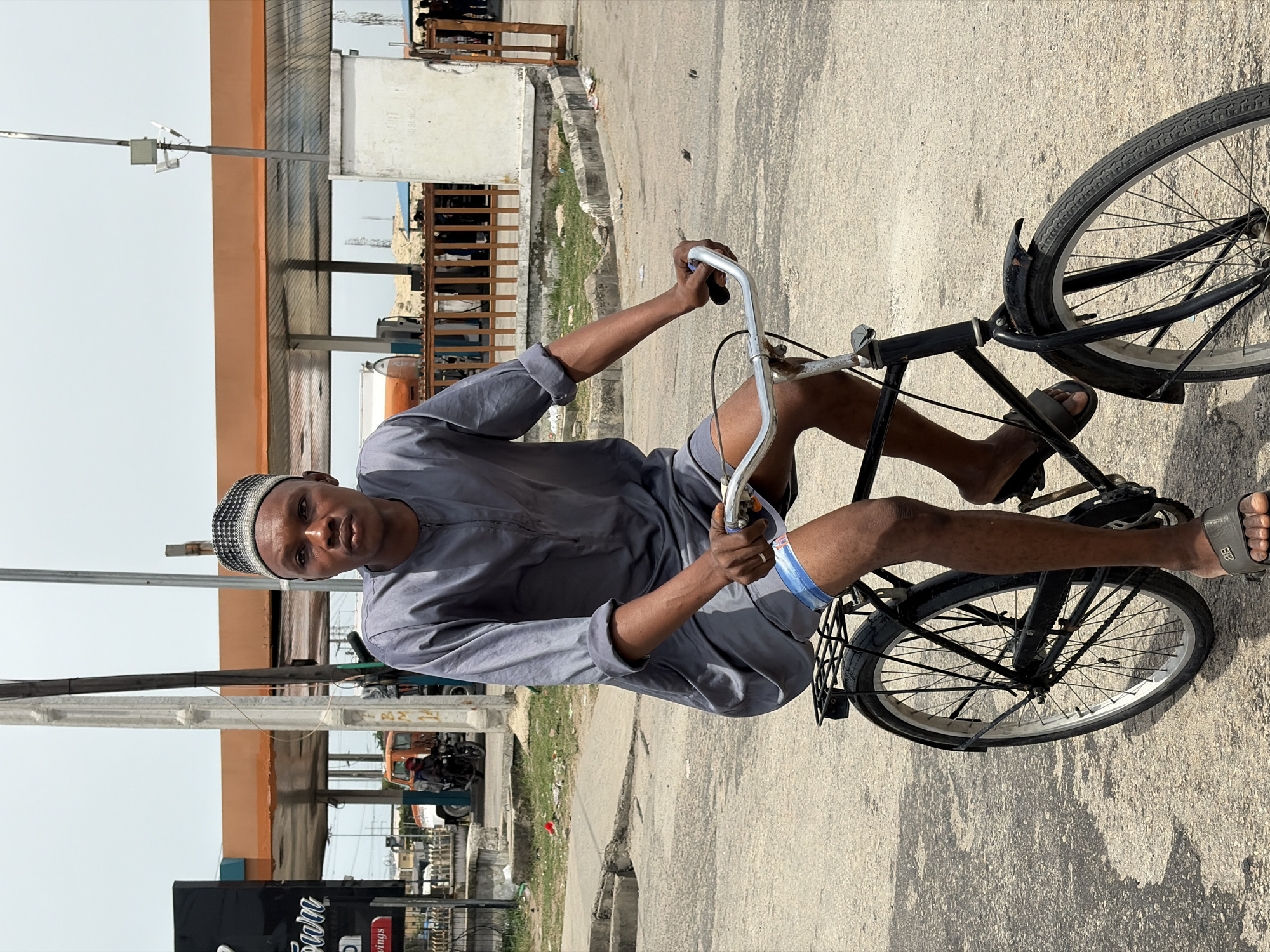 Man in traditional dress cycles through Igboefon, Nigeria