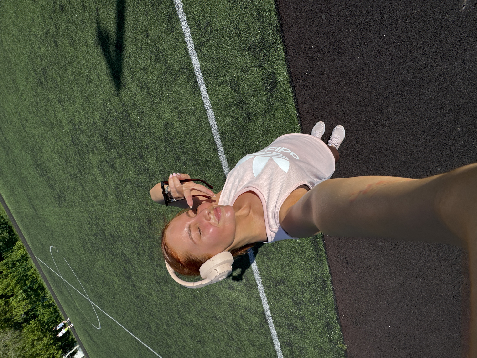 Woman takes playful selfie on sports field in Chaikovsky