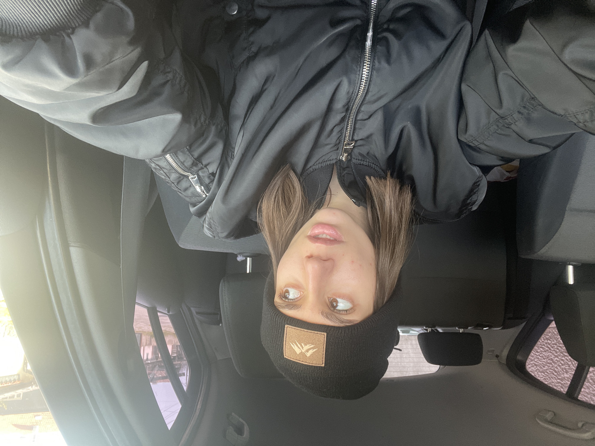Woman in black jacket observed in car backseat, Sofia