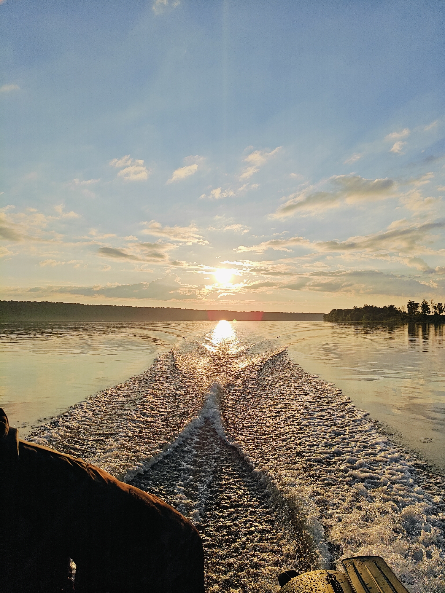 Boat on golden evening water, forested industrial shore, Chernushka