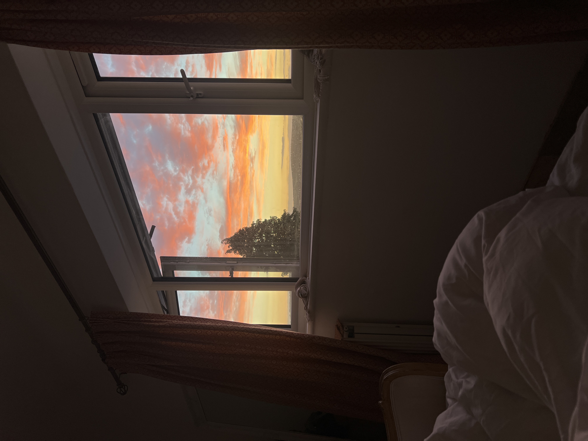 Brighton sunset viewed through a bedroom window at dusk