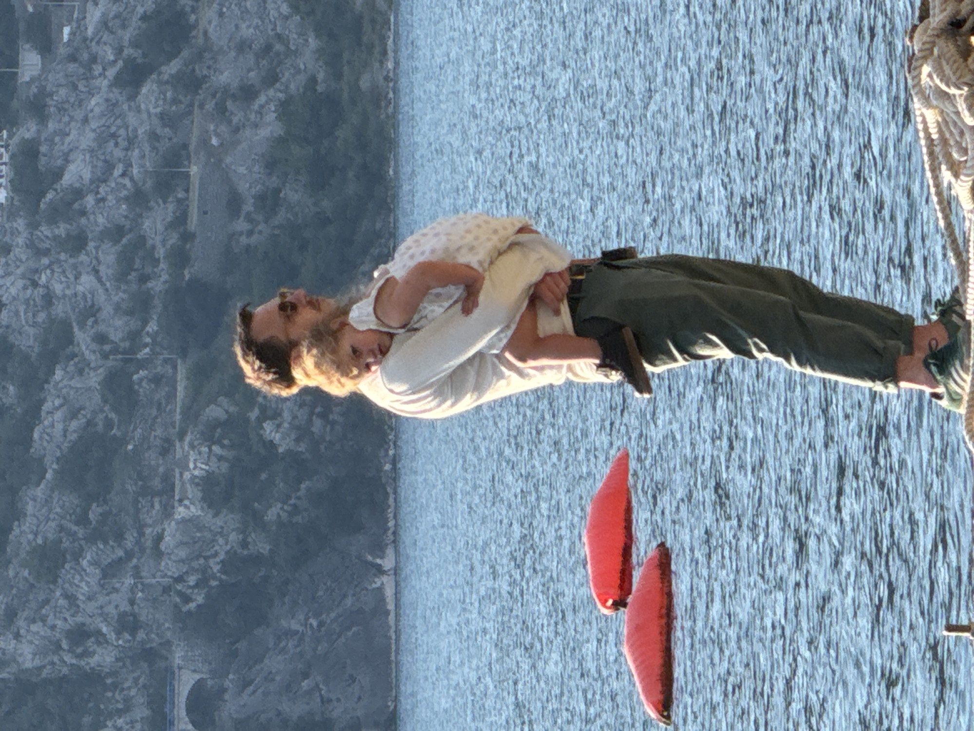 Father holds child on pier in Perast, Montenegro