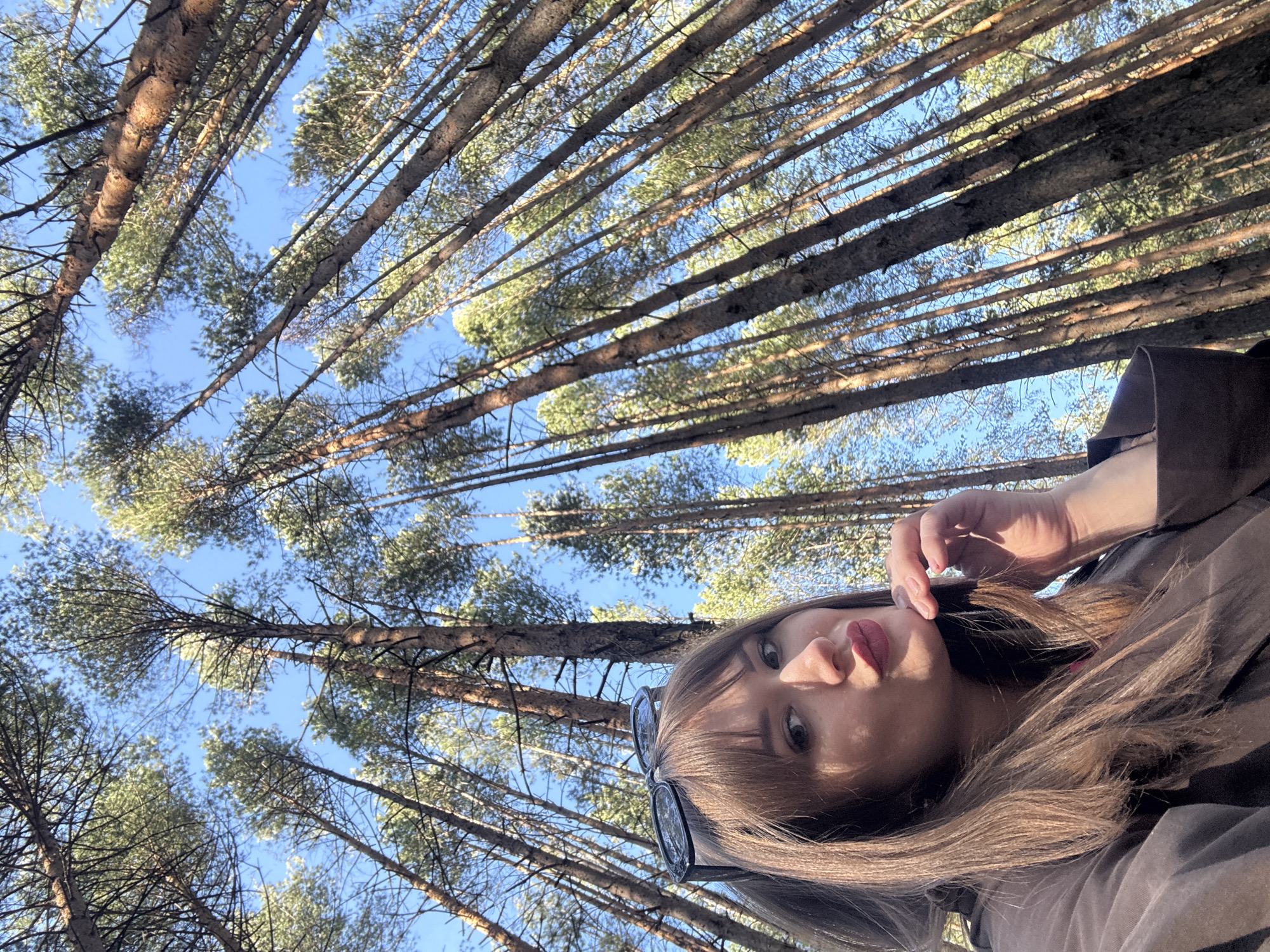 Woman takes selfies in pine forest near Chaikovsky, Russia
