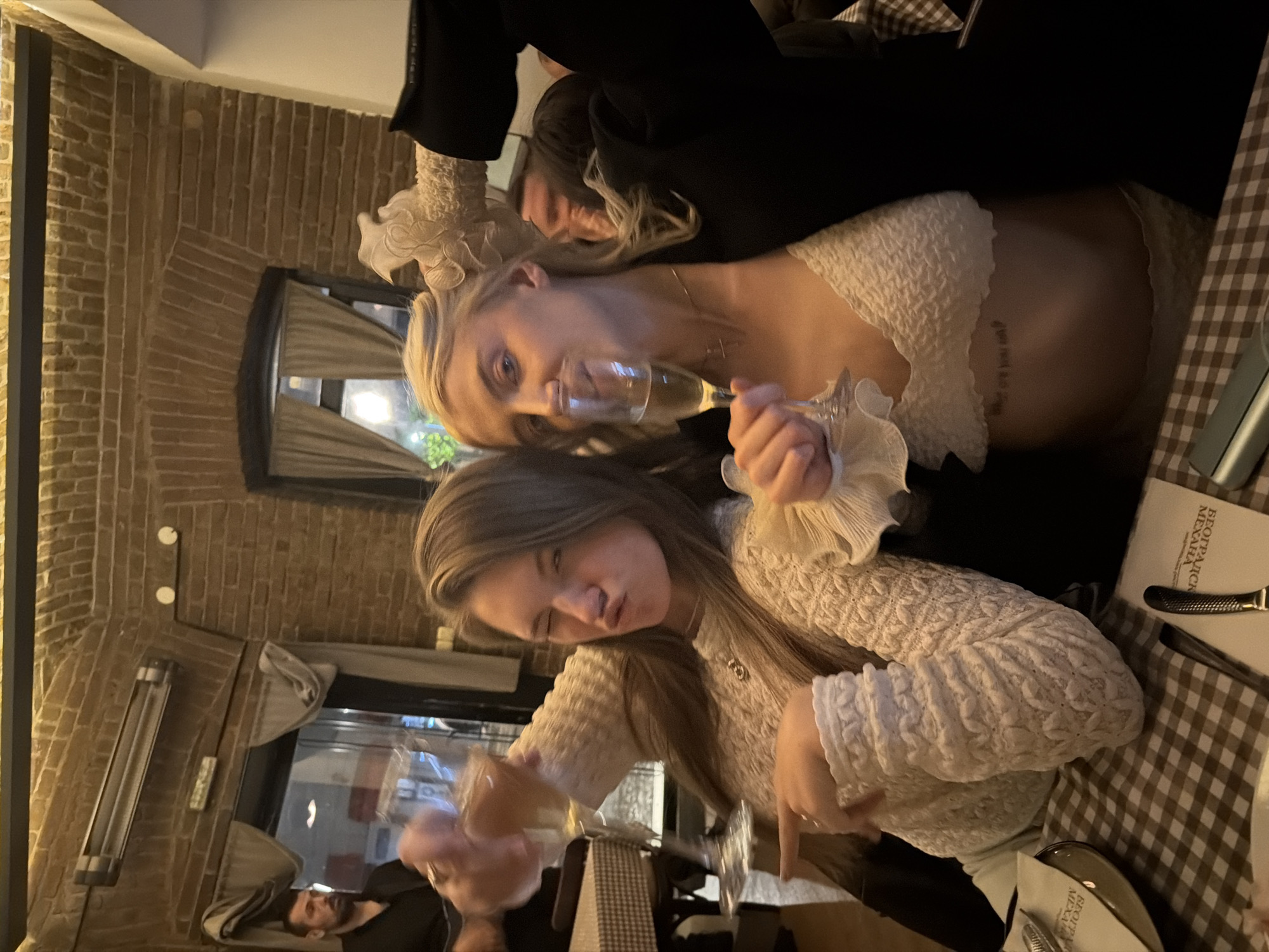 Two women pose with champagne glasses in Belgrade