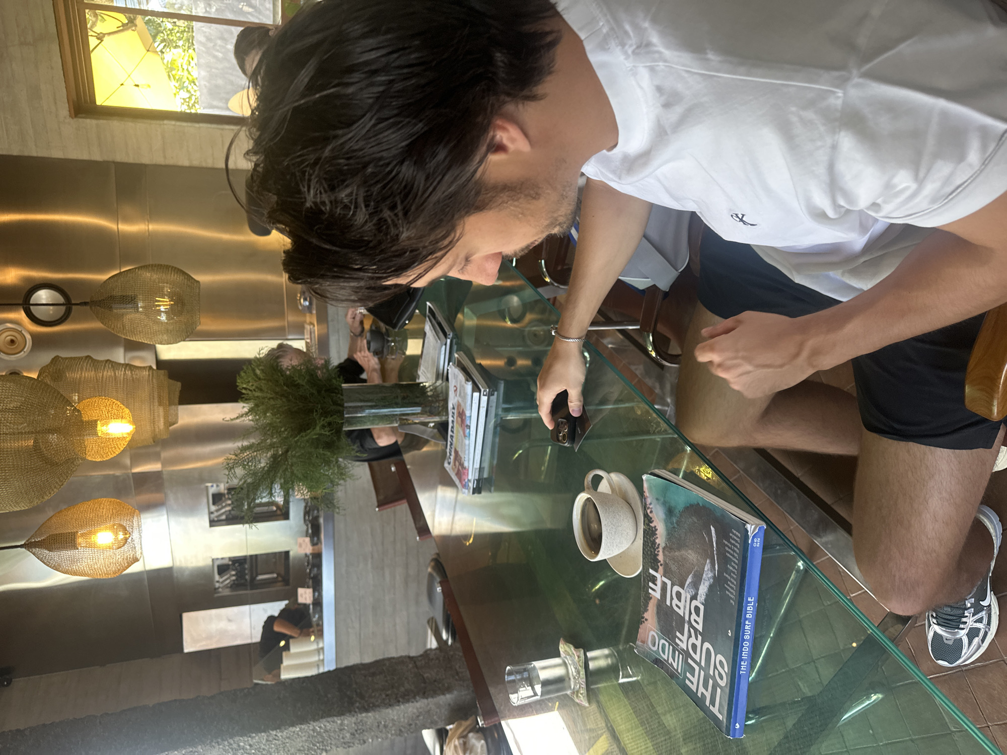 Cafe table session with vinyl, surf books, and a smoothie