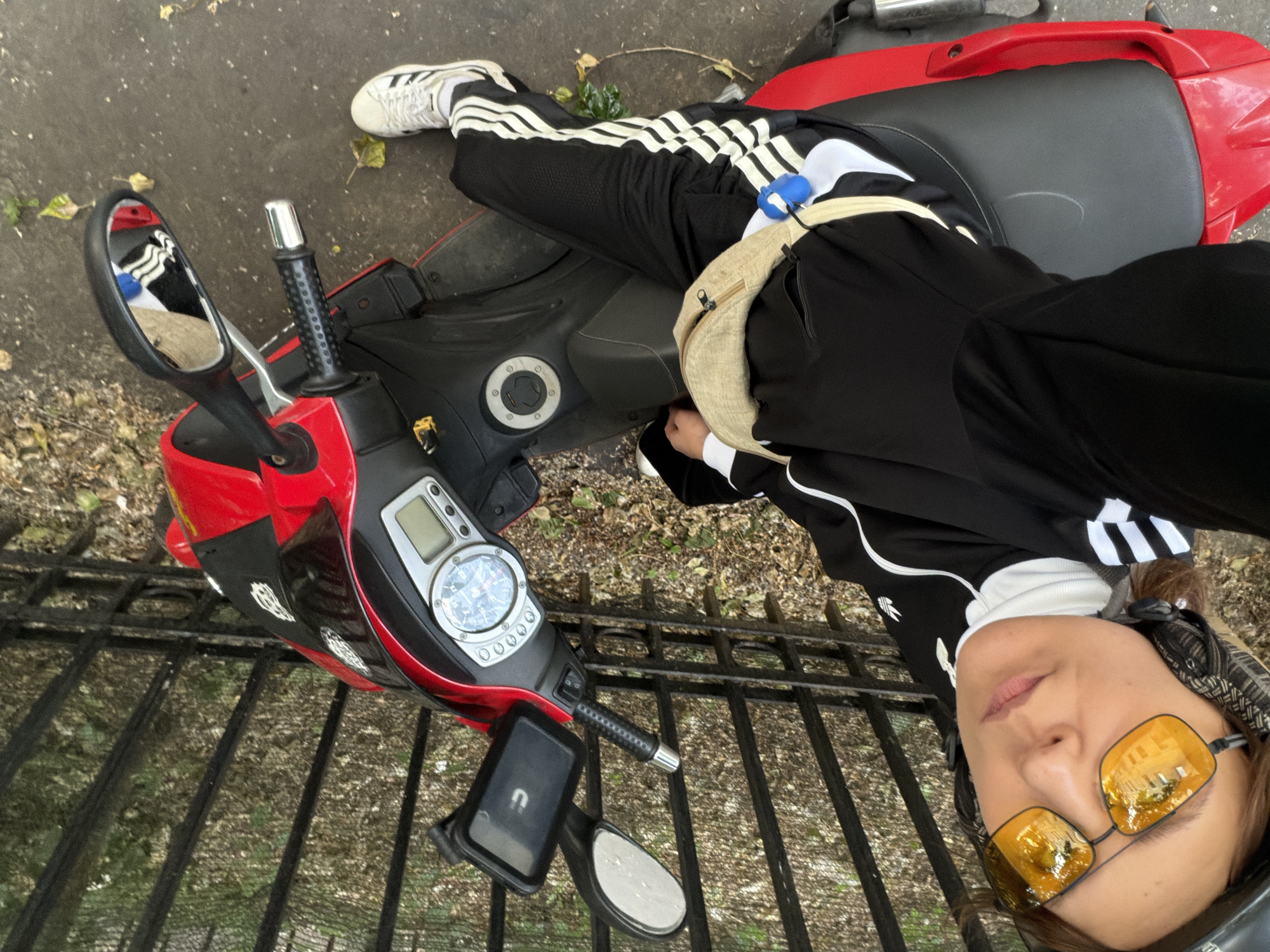 Relaxing on a red scooter in a sharp matching tracksuit