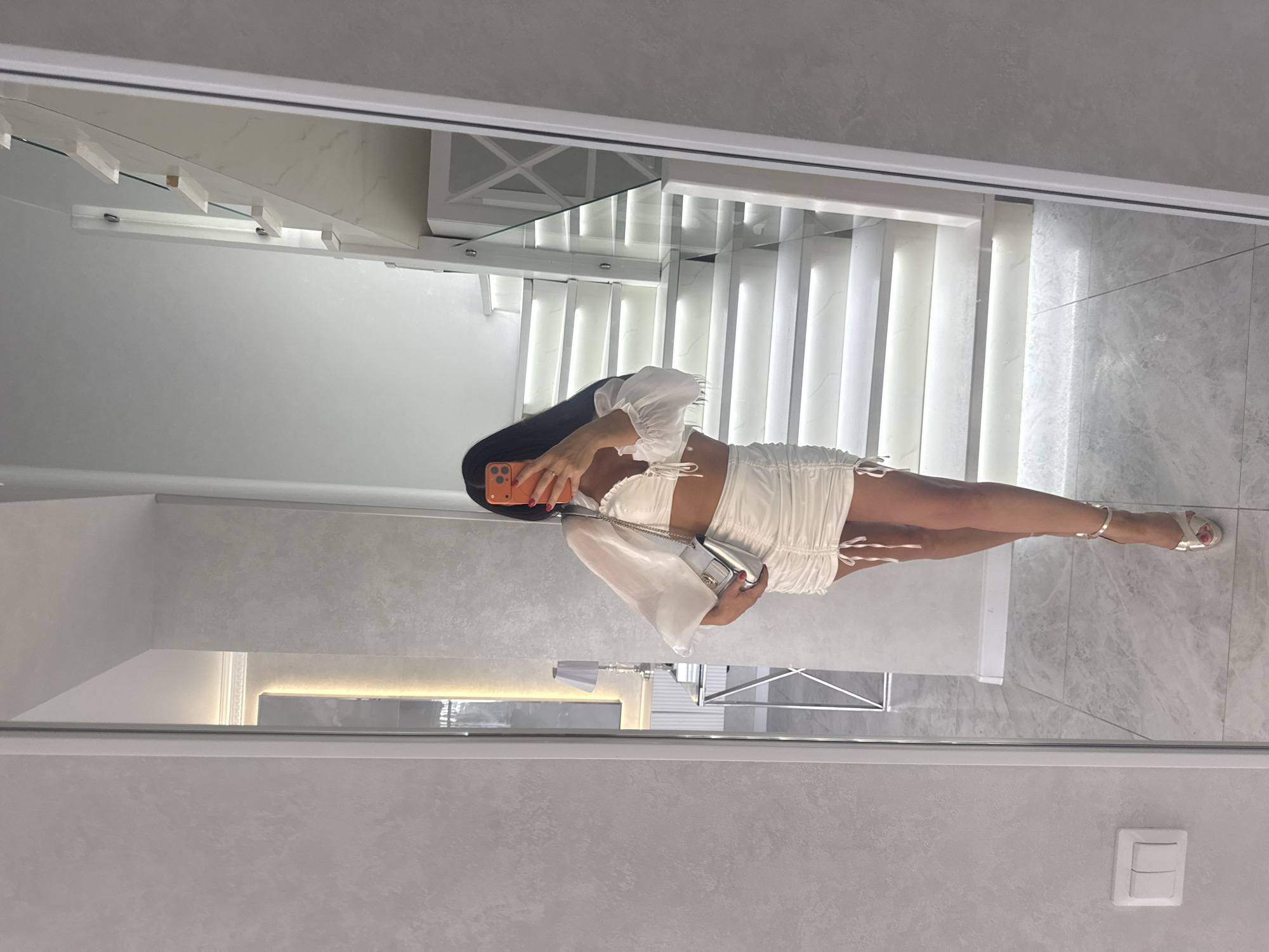 Mirror selfies showcasing a white ruched two-piece outfit in Malinovka