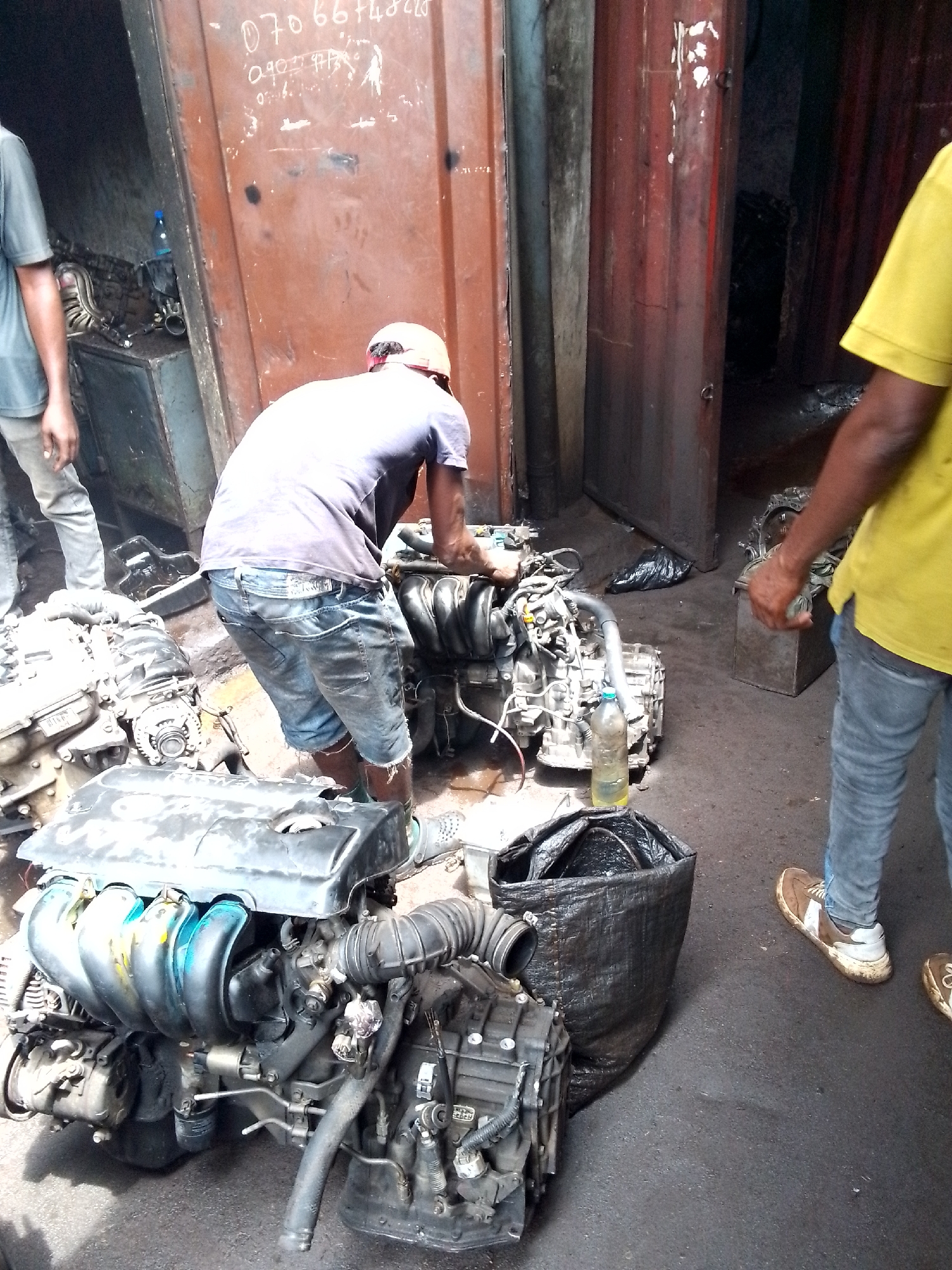 Mechanics work on engines at busy Onitsha auto market