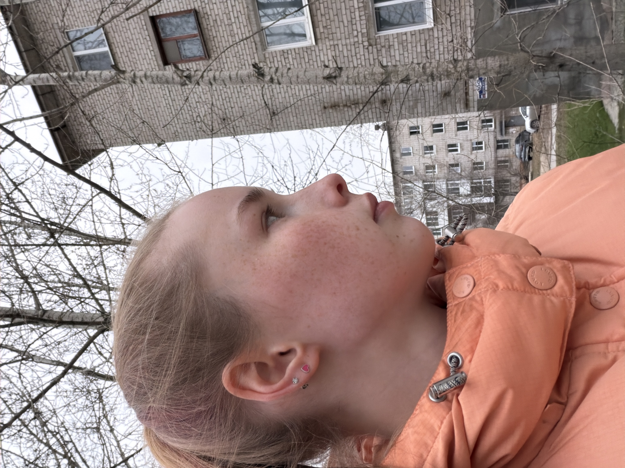 Young blonde person photographed looking skyward in Berezniki