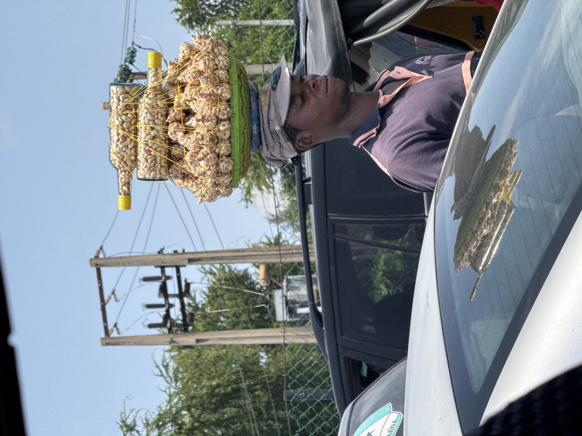Street vendor carries goods in basket through Lekki, Nigeria