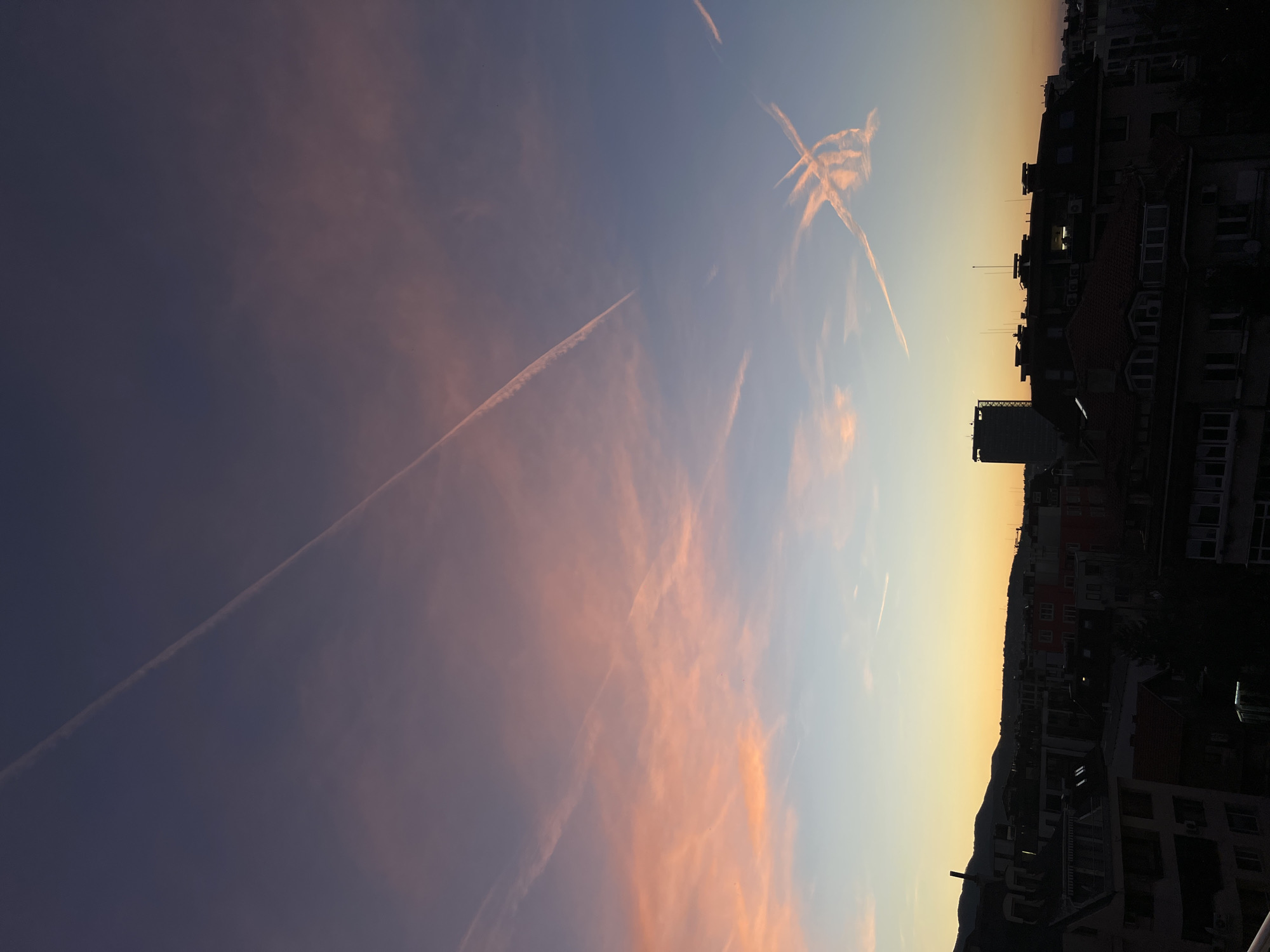 Evening contrails streak across sunset sky in Sofia