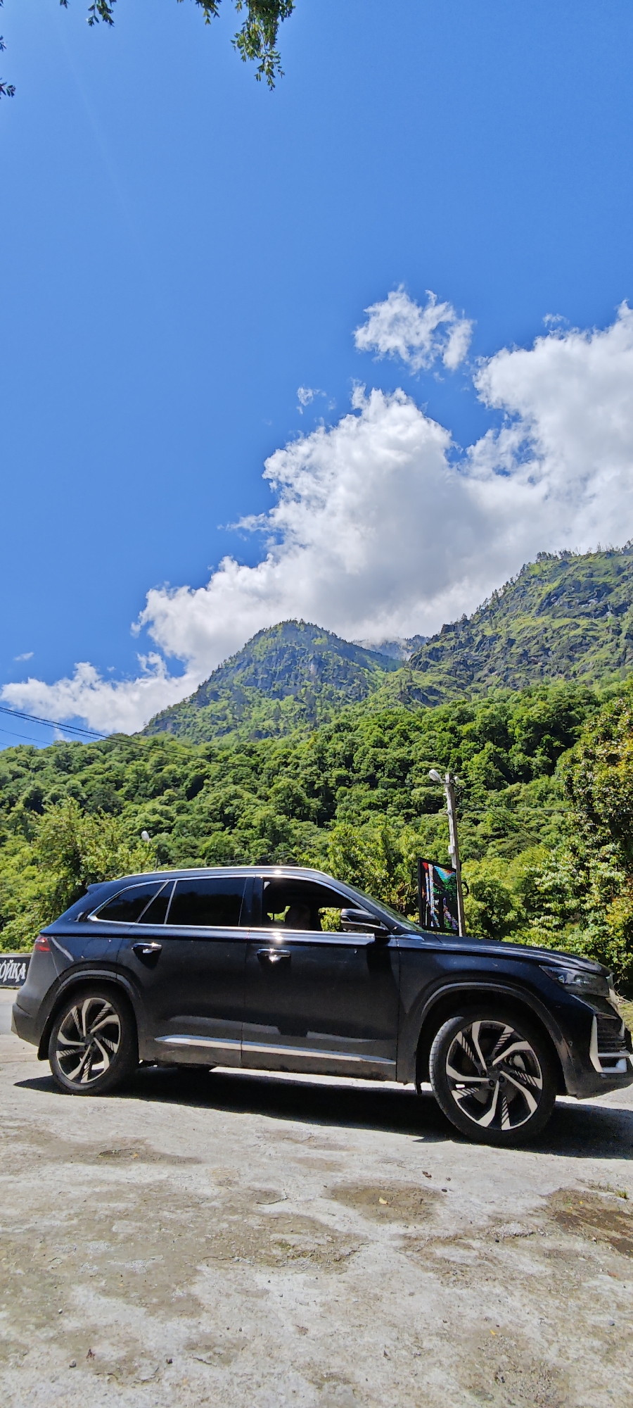 SUV parked roadside amid mountain scenery in Bzypta, Abkhazia