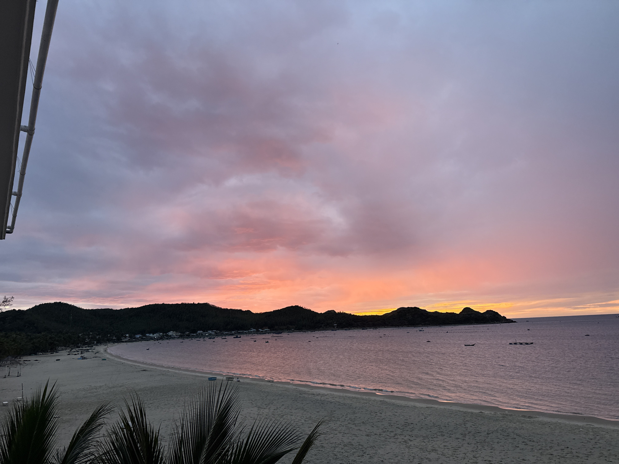 Sunset settles over a quiet crescent beach in Hòa Hiệp