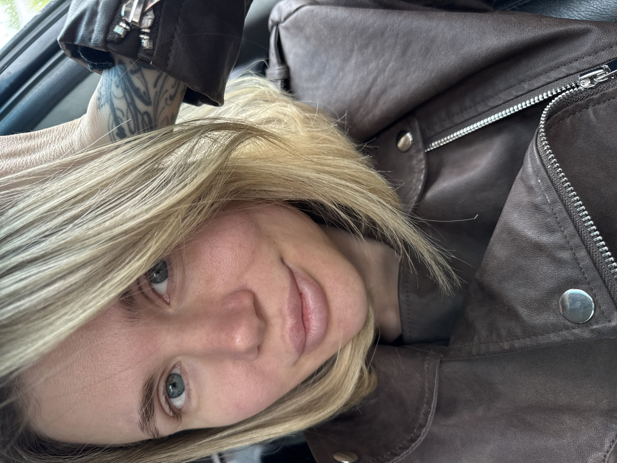 Blonde woman in leather jacket observed indoors in Gorno-Altaysk
