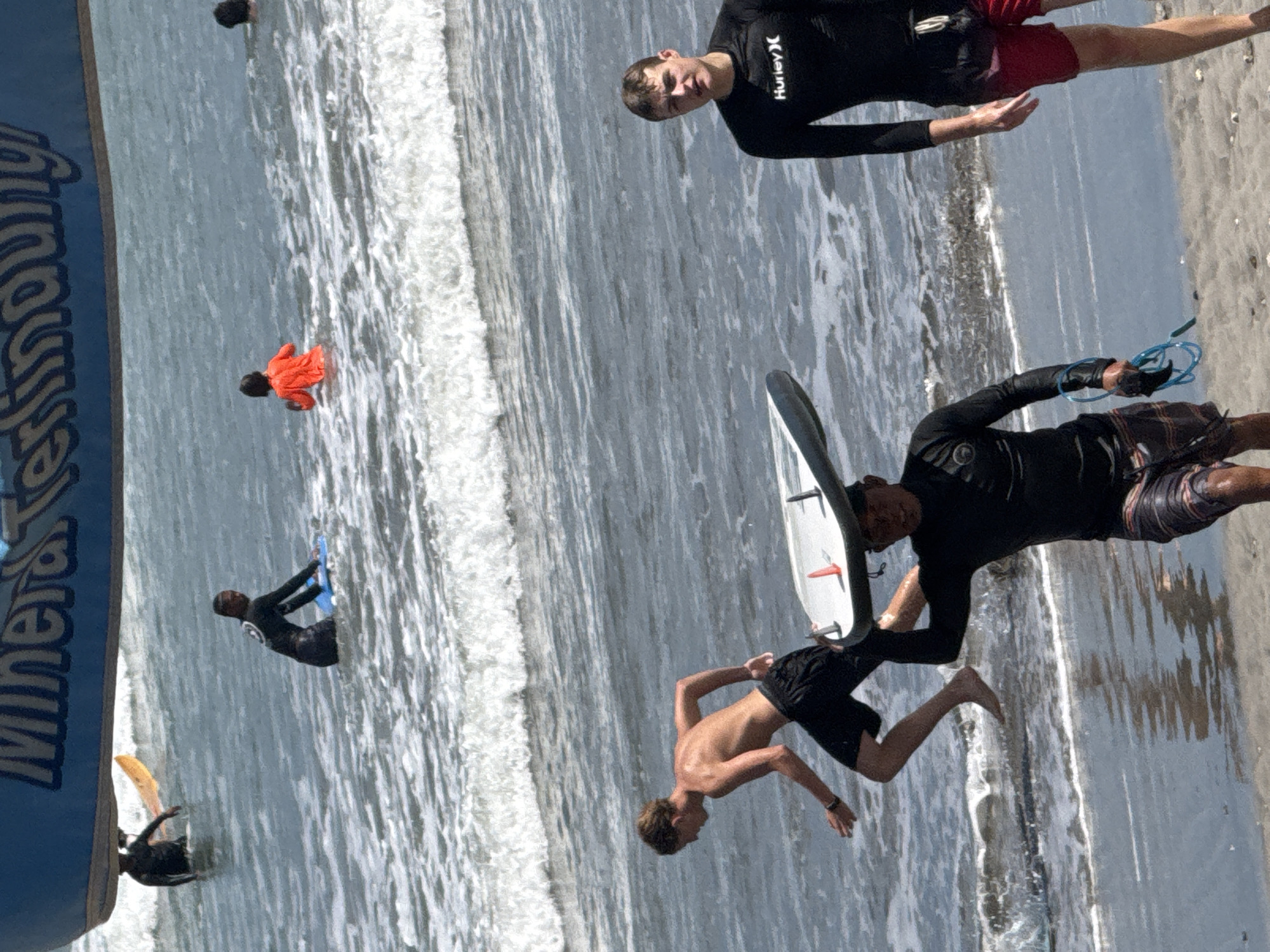 Surfers and beachgoers hit the waves at Kuta Beach
