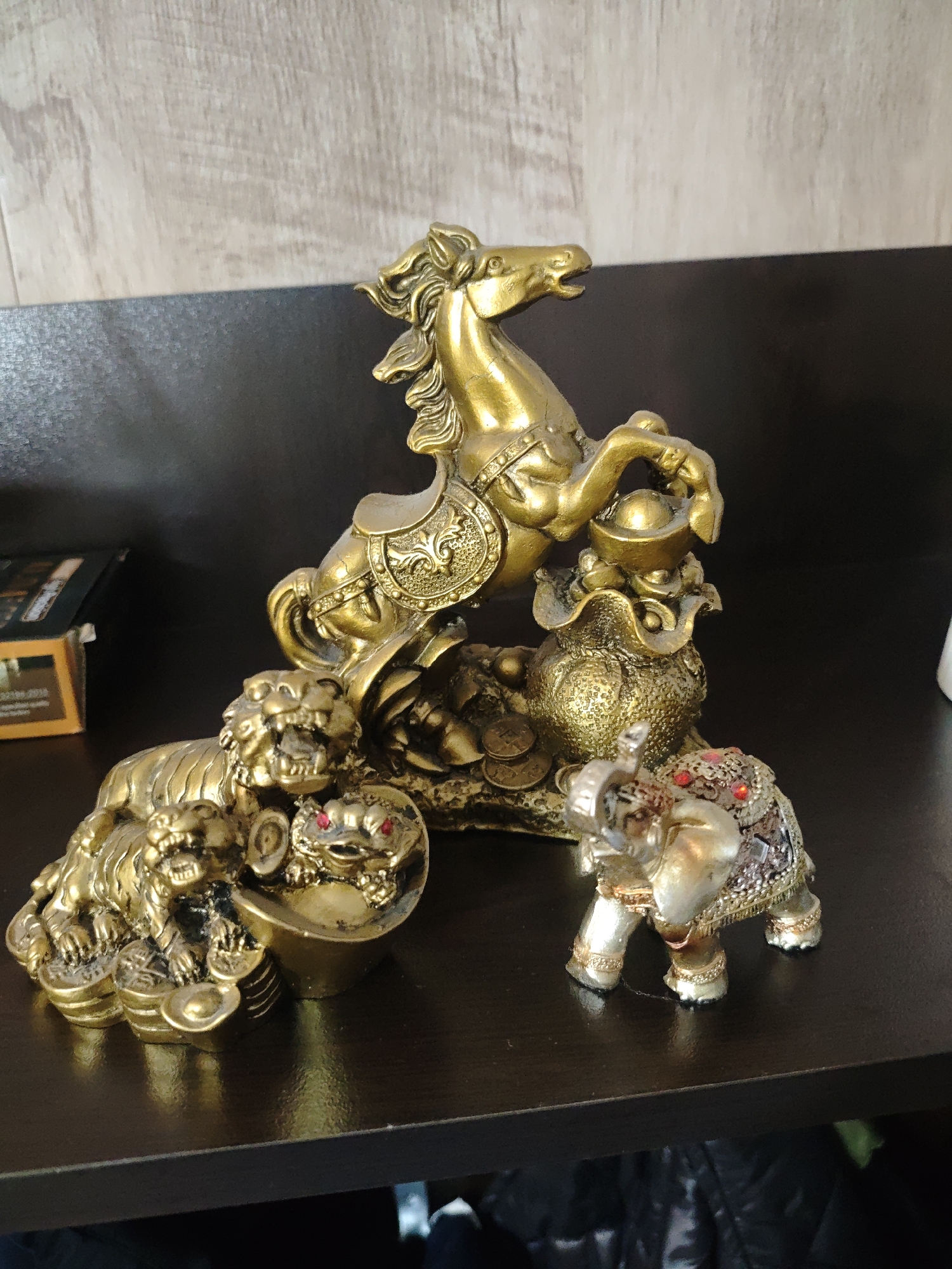 Golden animal figurines and cat observed in indoor setting