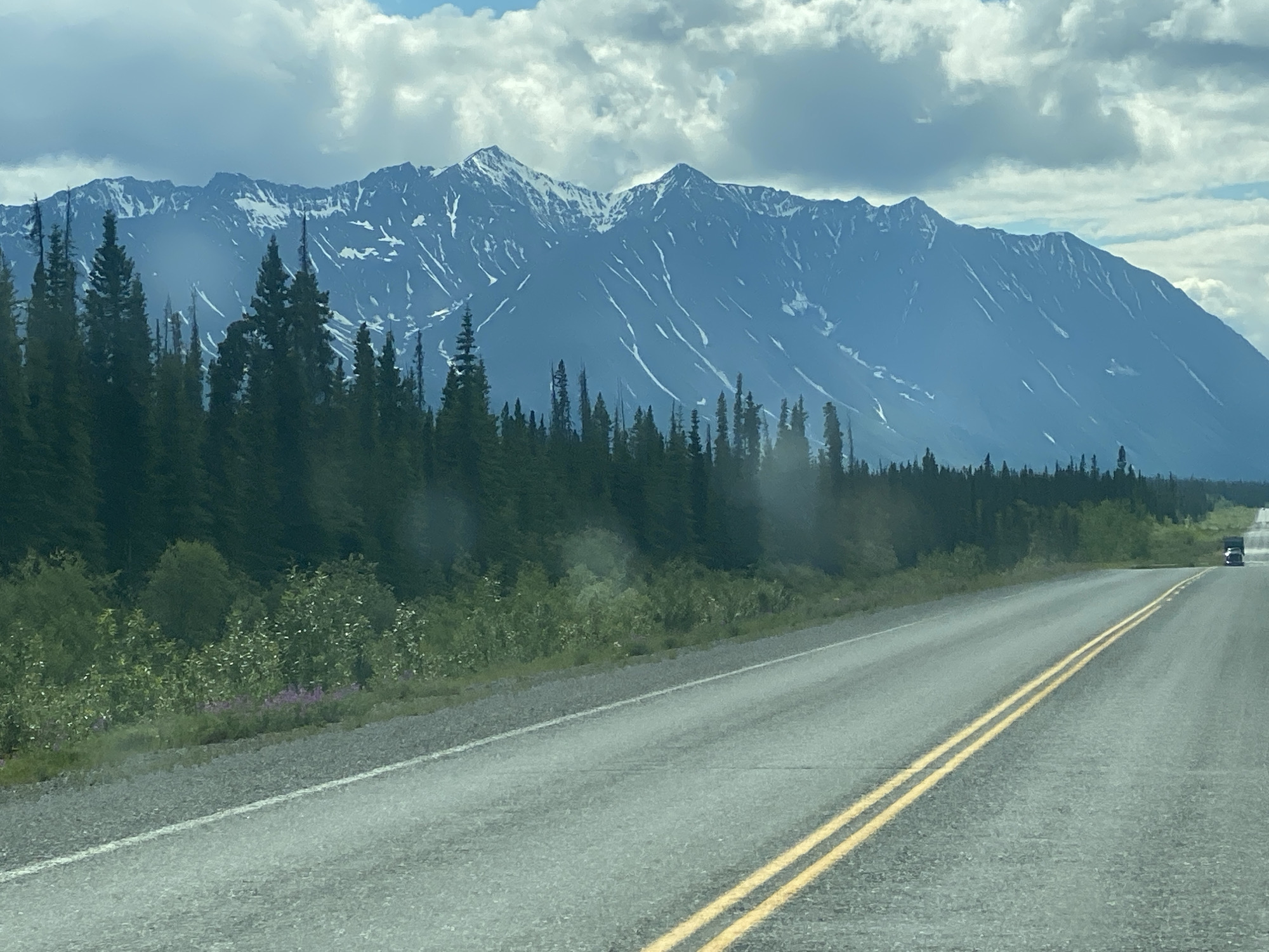 Empty two-lane highway curves through the Yukon wilderness