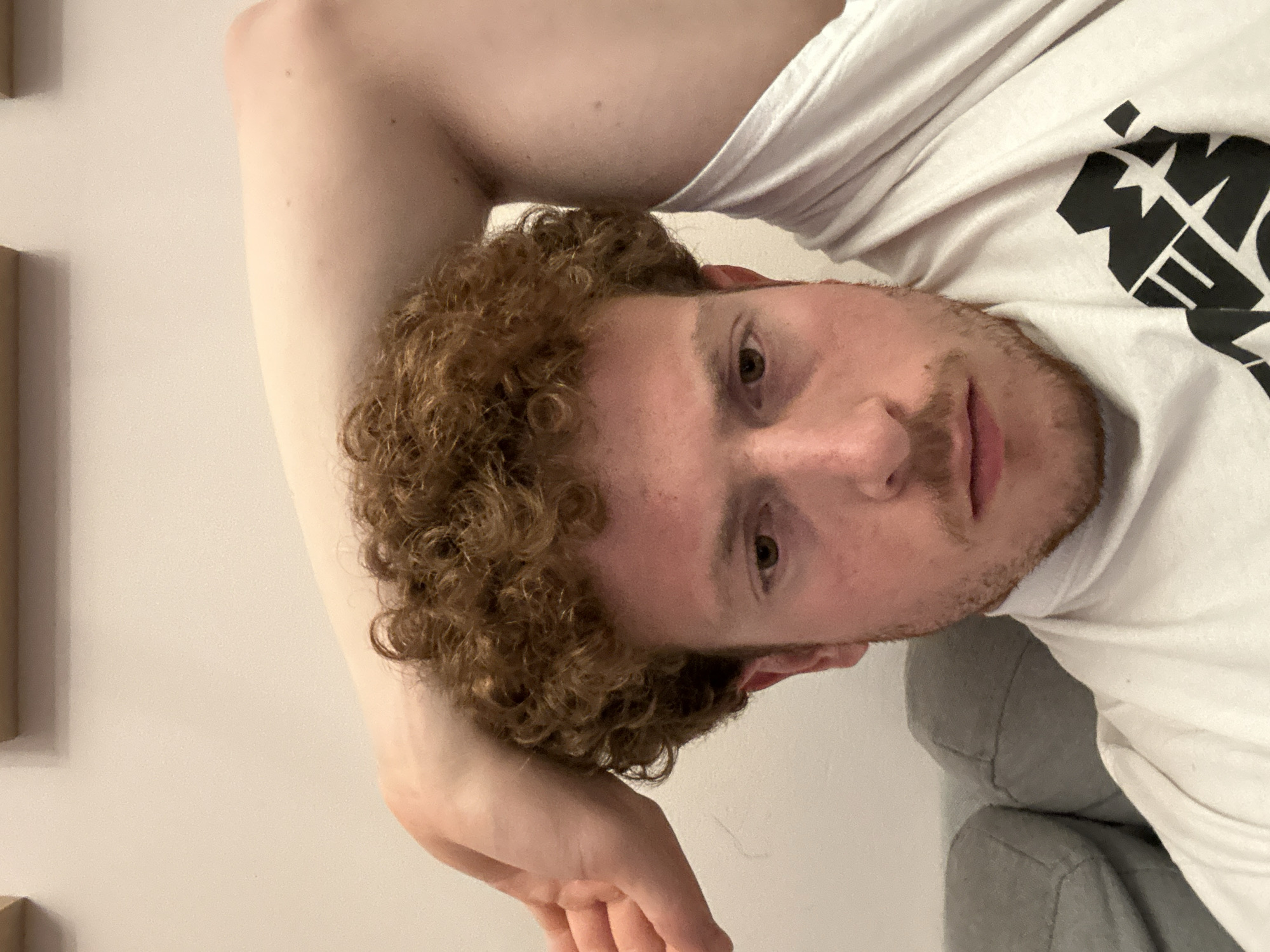 Person resting in white graphic t-shirt observed in NYC