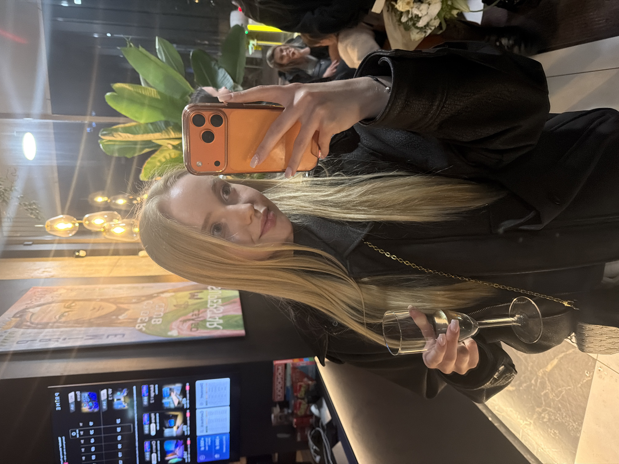 Woman takes selfie with wine at upscale lounge