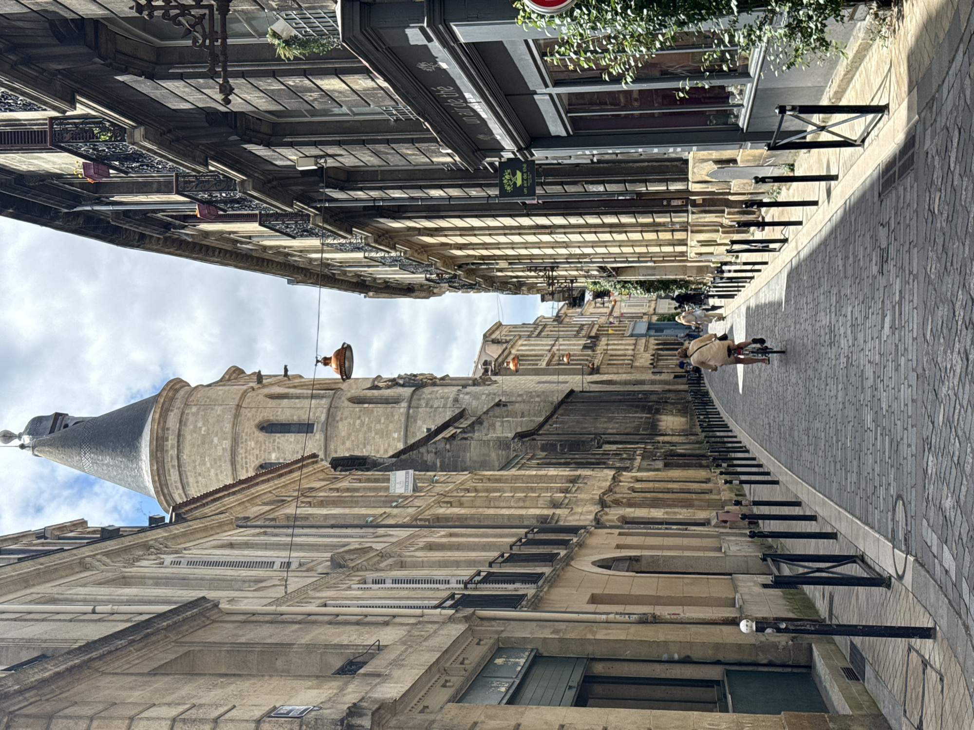 Tourist documents medieval Bordeaux streets during midday walking tour
