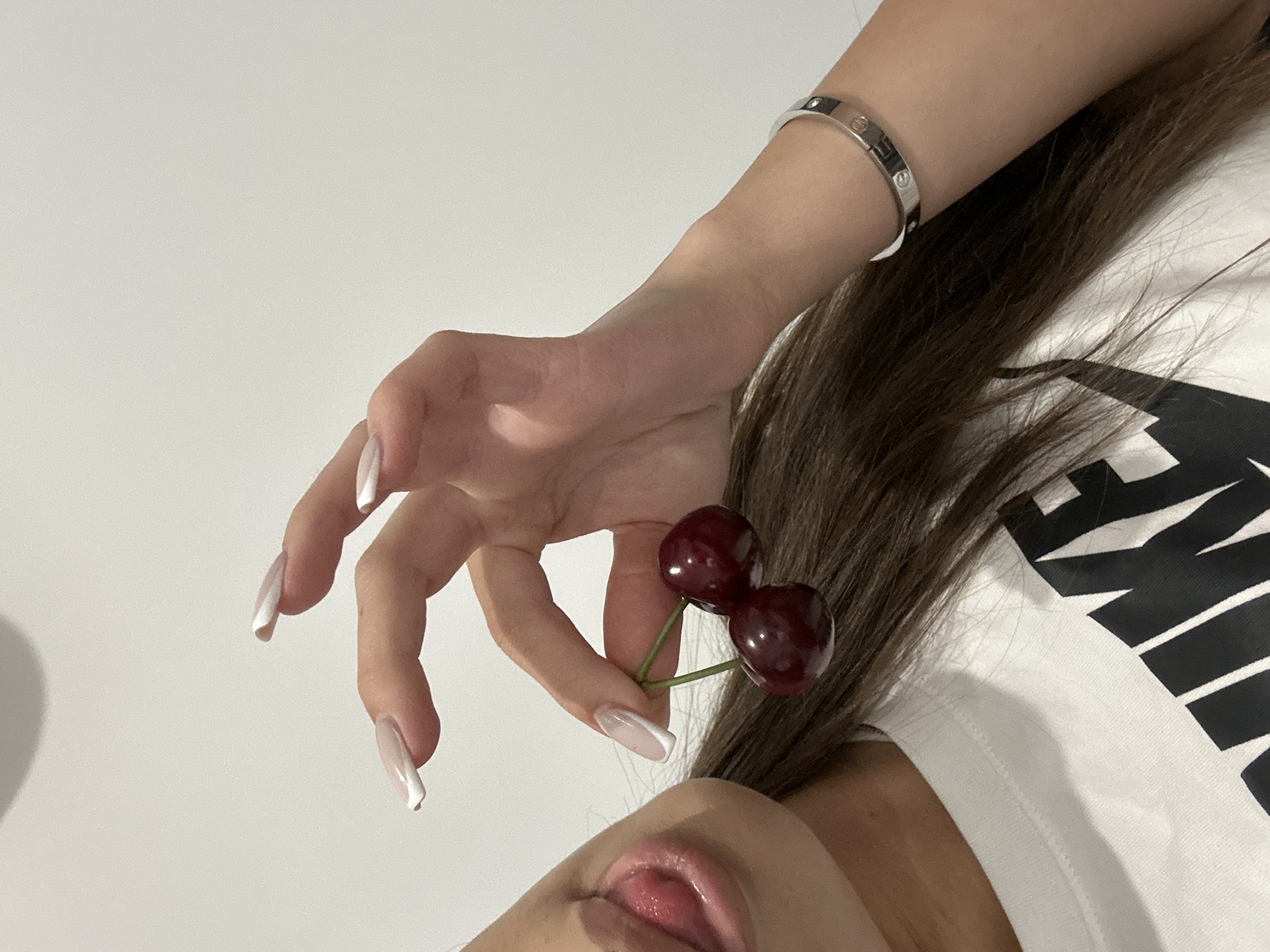 Person with cherries, ripe banana photographed at same location