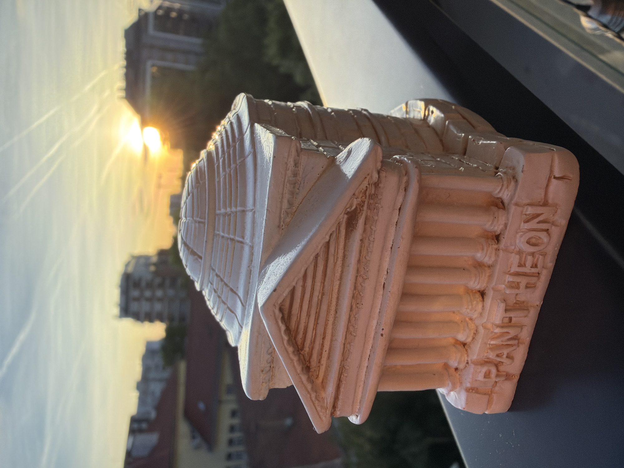 Witness documents miniature still-life arrangements against urban sunset backdrop