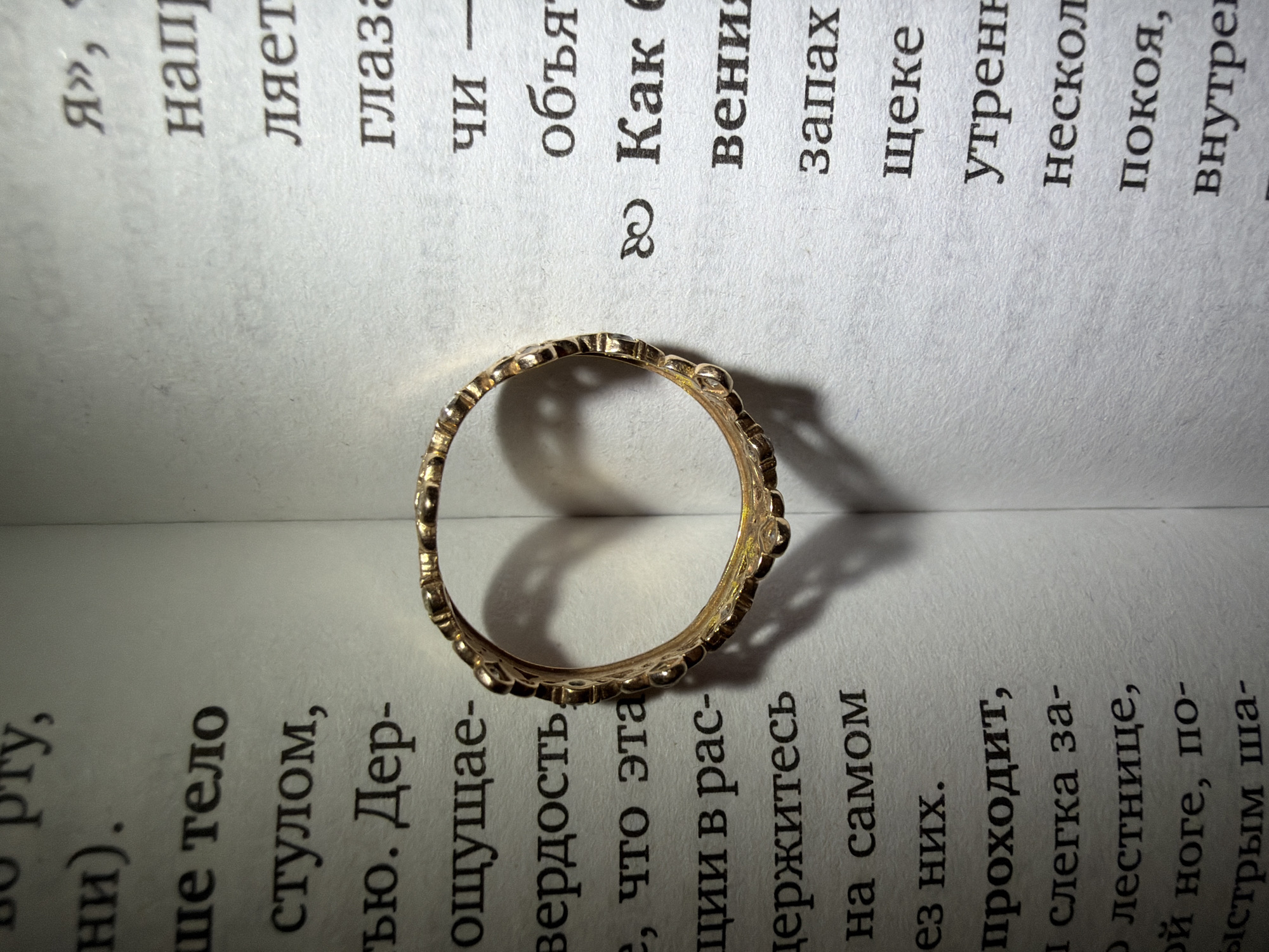 Gold crown ring photographed in artistic arrangements with books, flowers