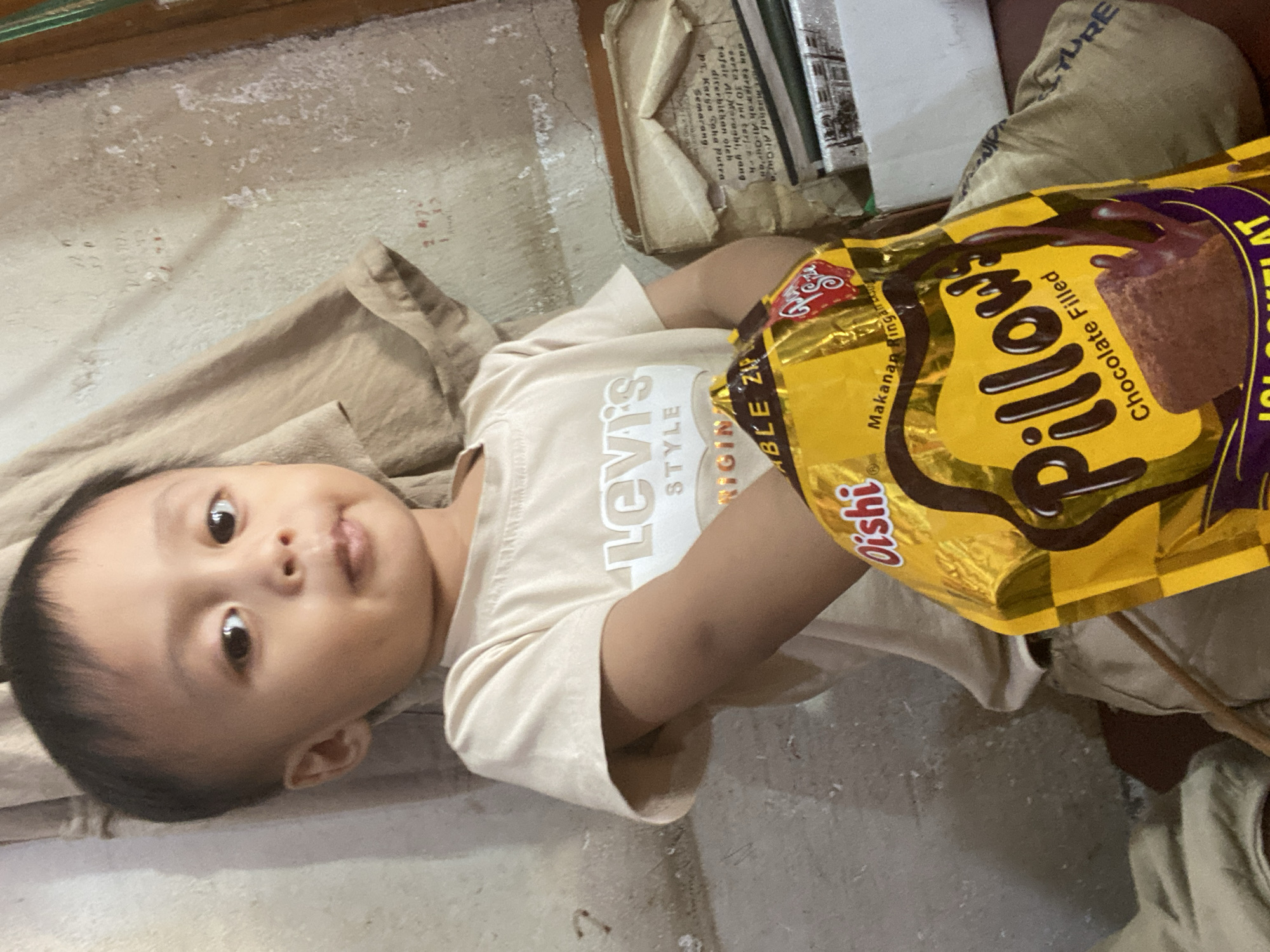 Child drinks fresh coconut at a Ta', Indonesia market stall