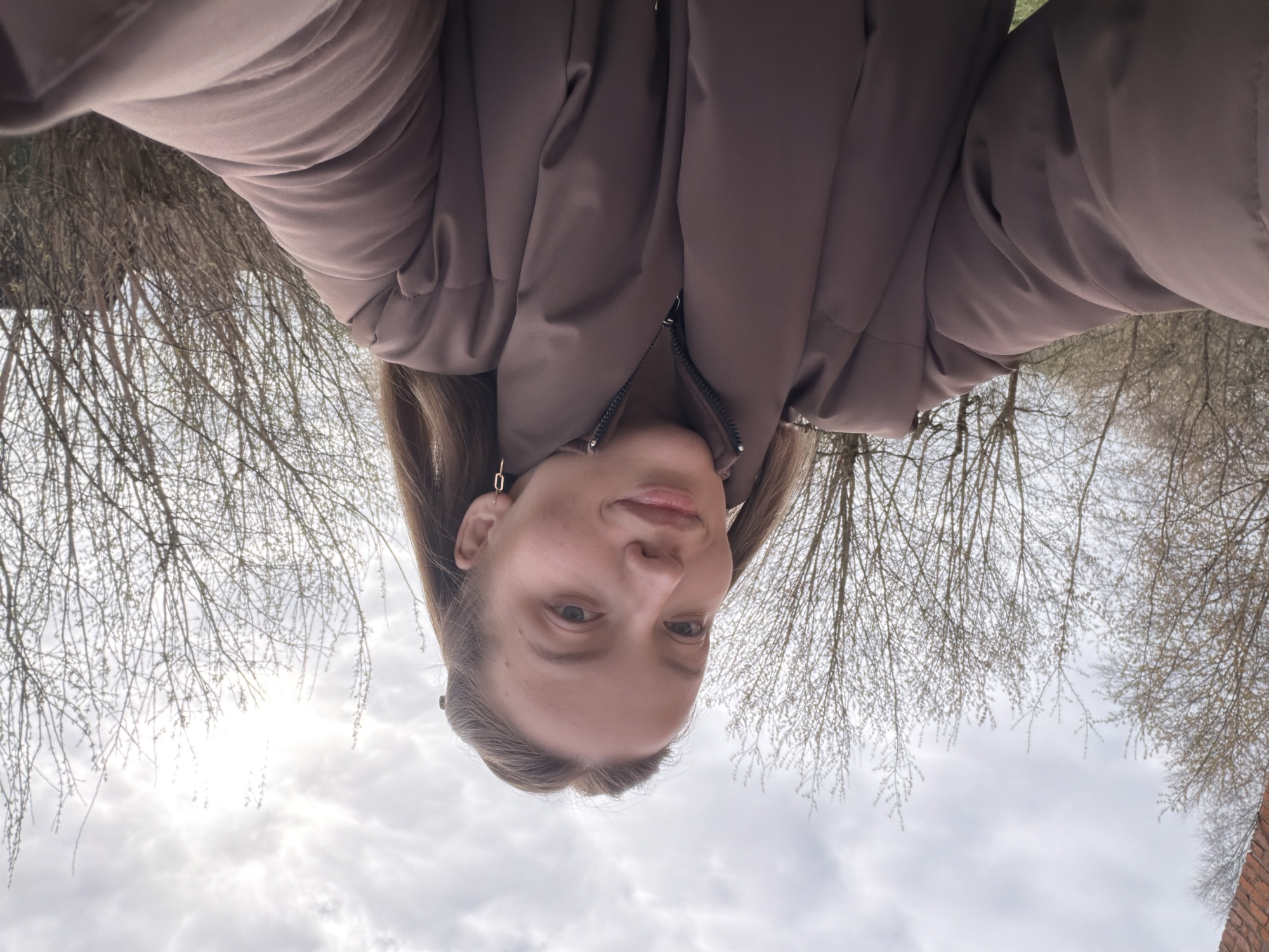 Woman takes selfie, walks outdoors in overcast Reshetnikovo morning